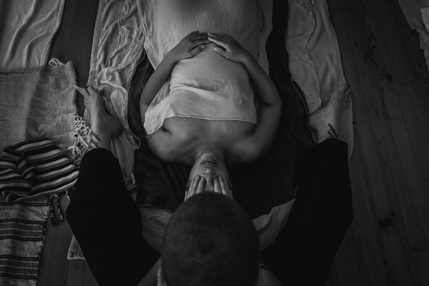 Black and white artistic portrait of someone resting on a dark background.