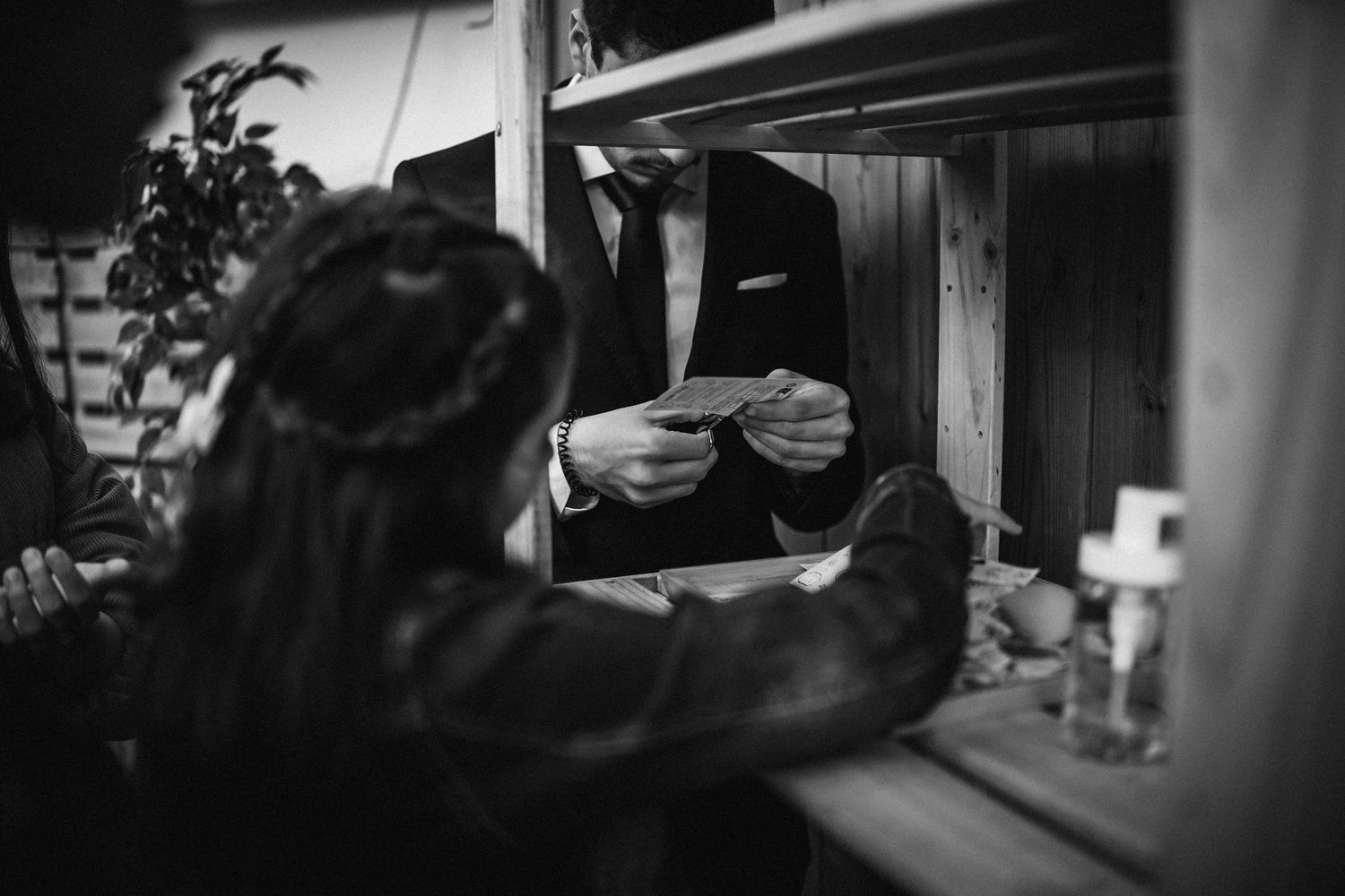 Artistic black and white composition of wedding ceremony details through window reflections.