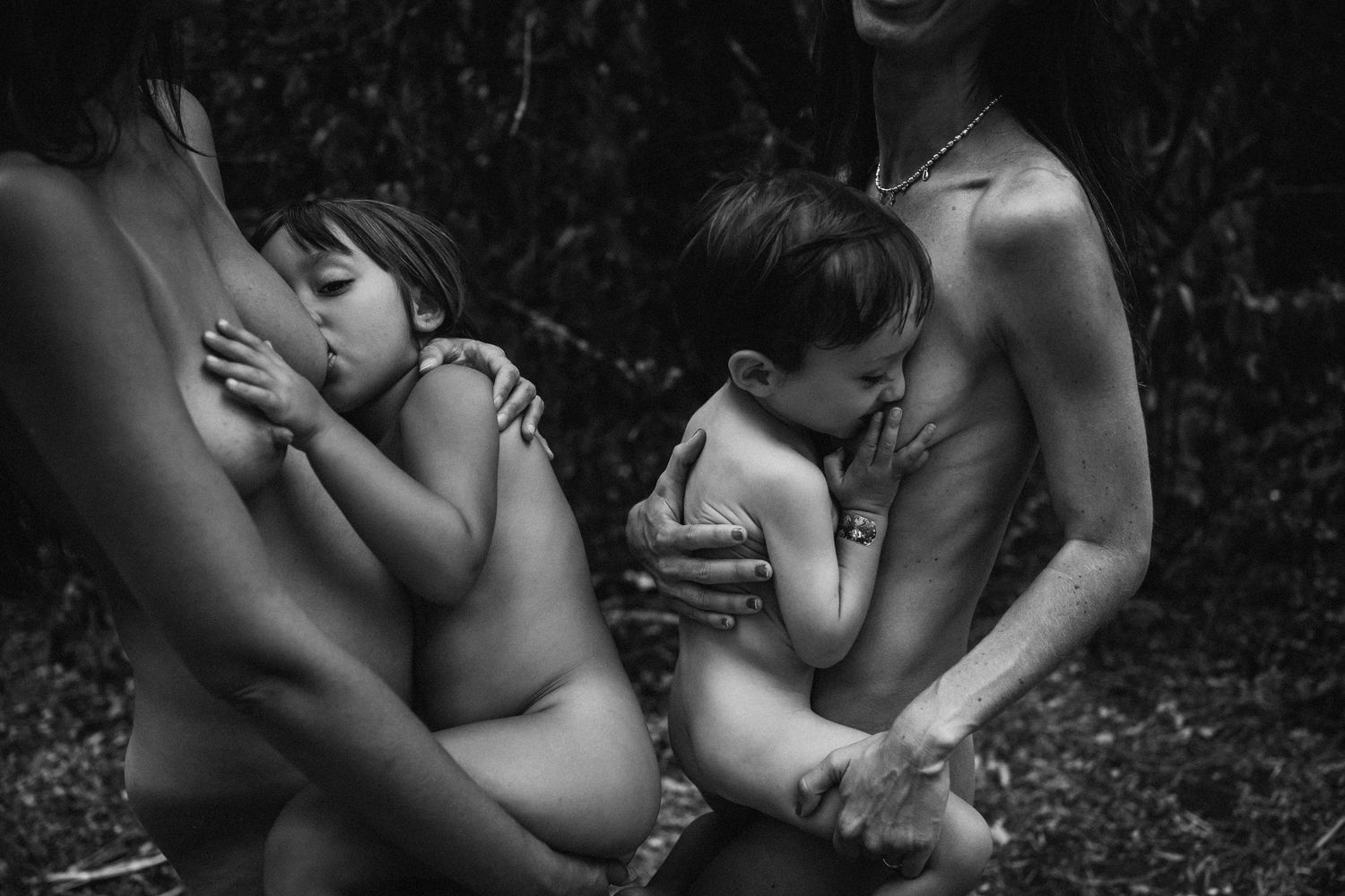 Artistic monochrome photography showing nurturing moments in natural setting.