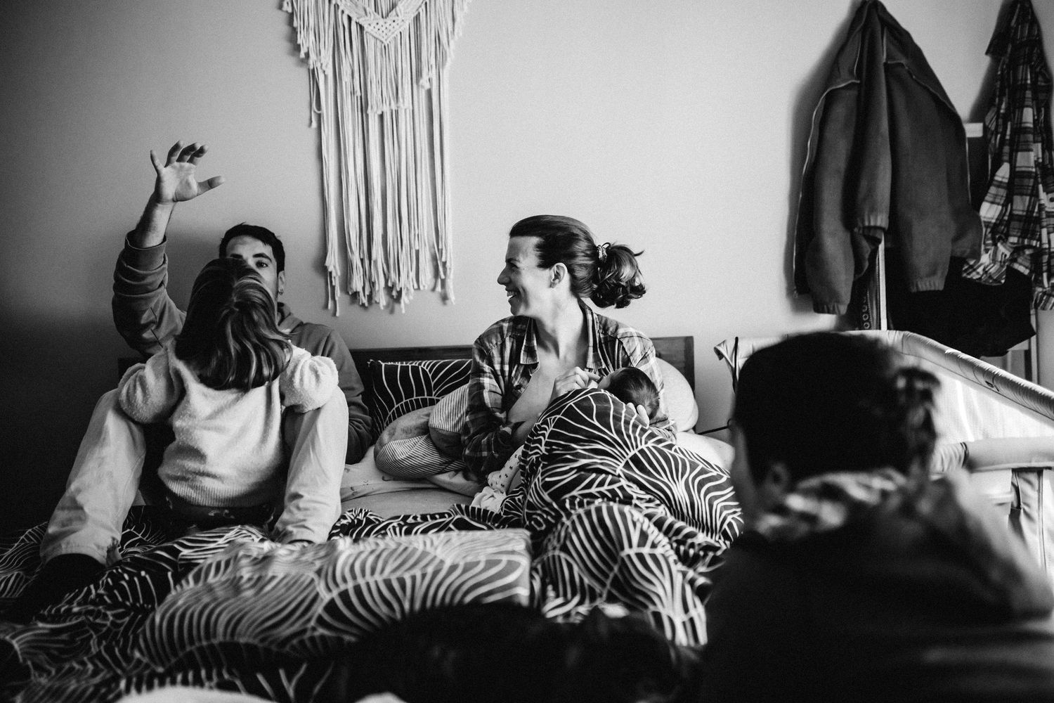 Black and white indoor scene with macrame wall hanging and relaxed atmosphere.