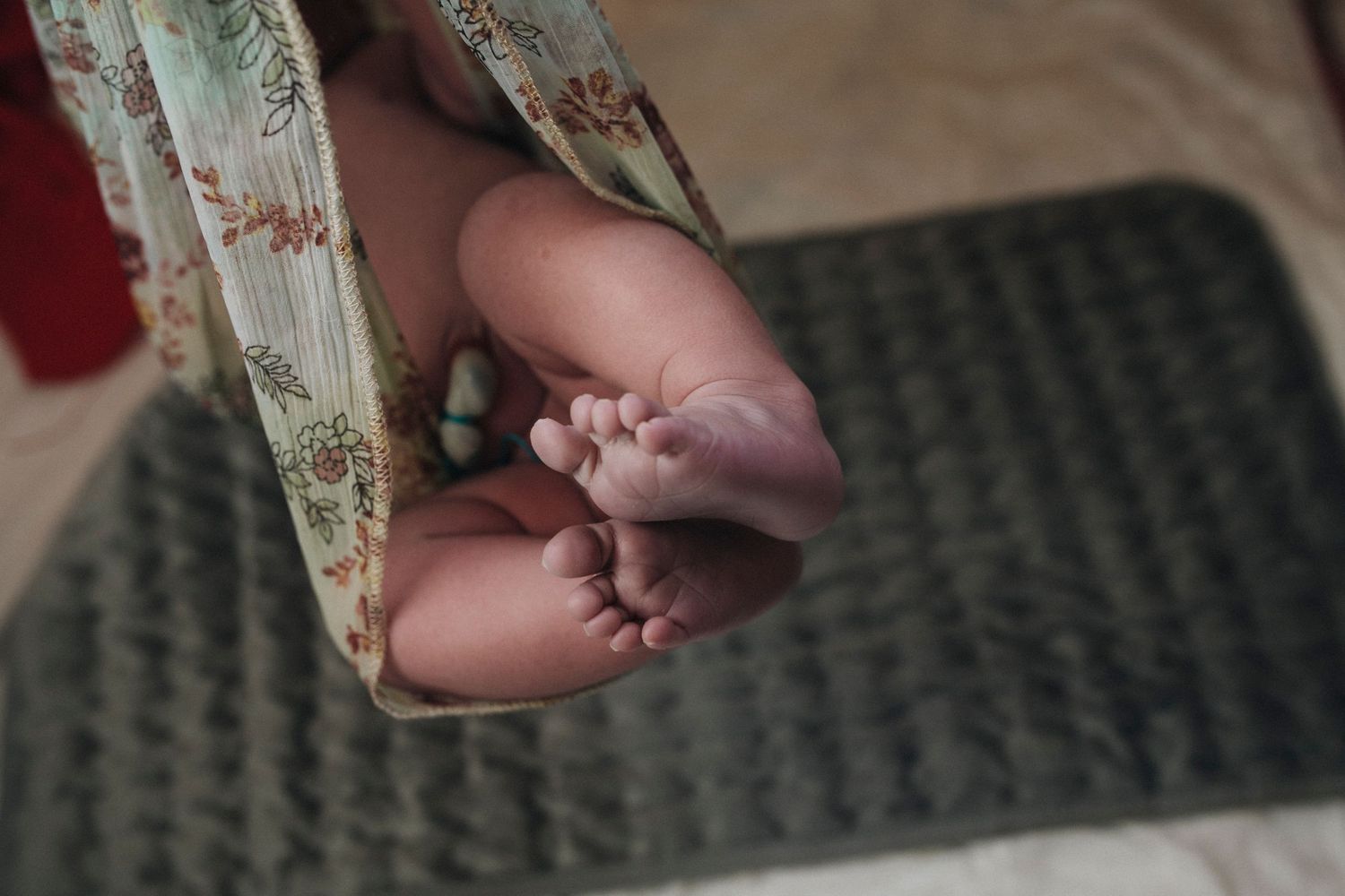 Close-up of tiny newborn feet against a textured background.