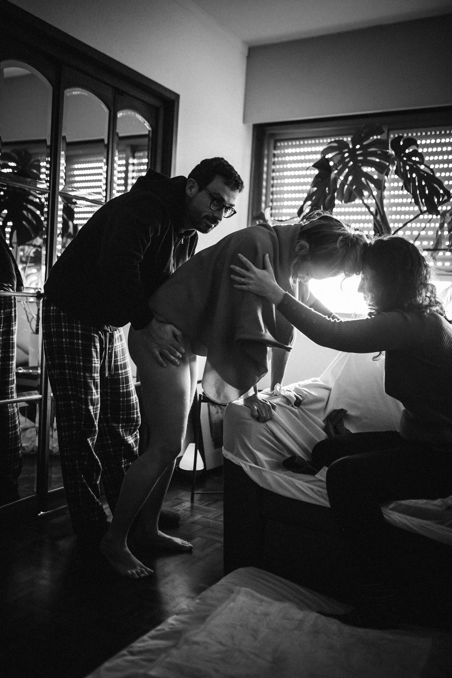 A series of black and white photos showing the progression of a person doing a push up exercise in silhouette.