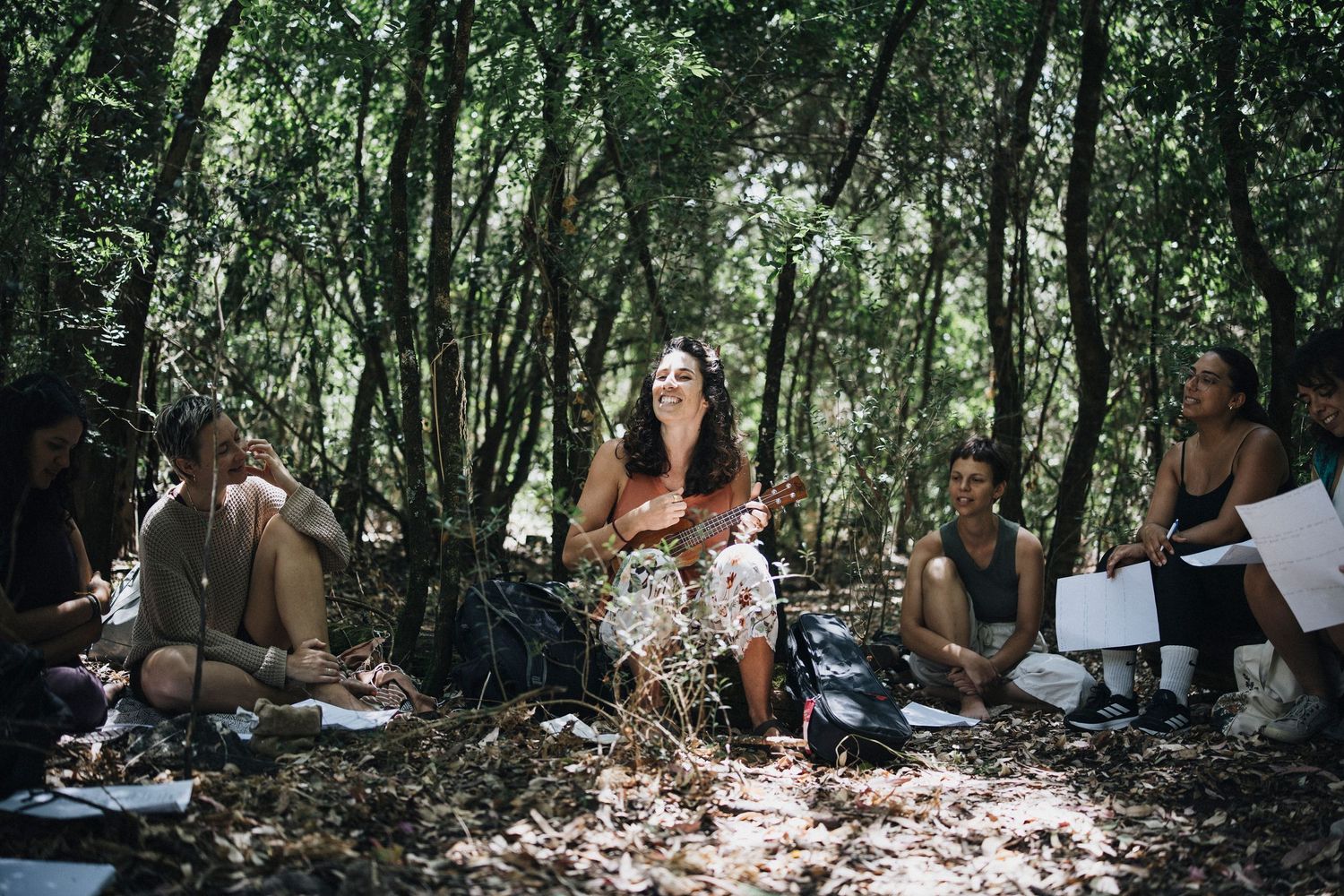 Group gathered in a shaded forest clearing for an outdoor session.