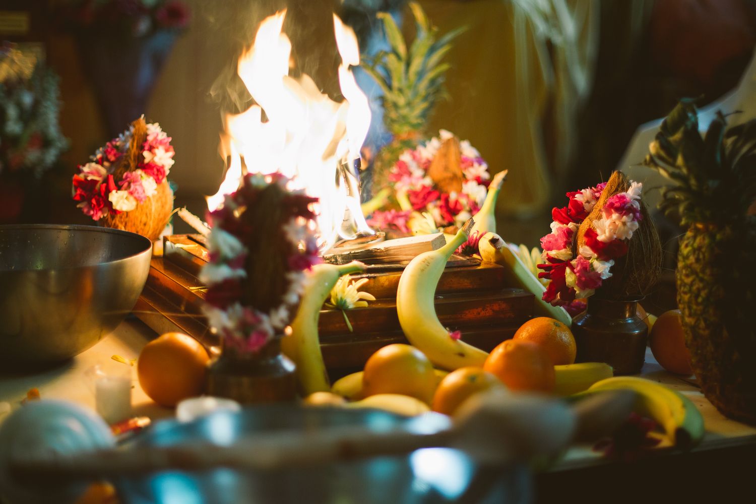 Decorative display with fruits and flowers illuminated by warm candlelight.
