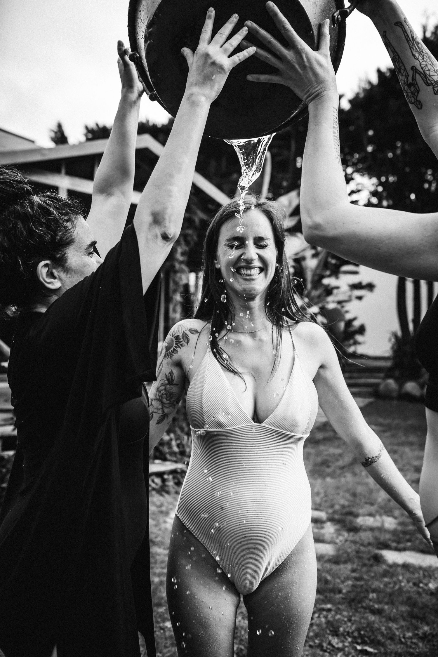 People splashing and playing with water outdoors in black and white photography.
