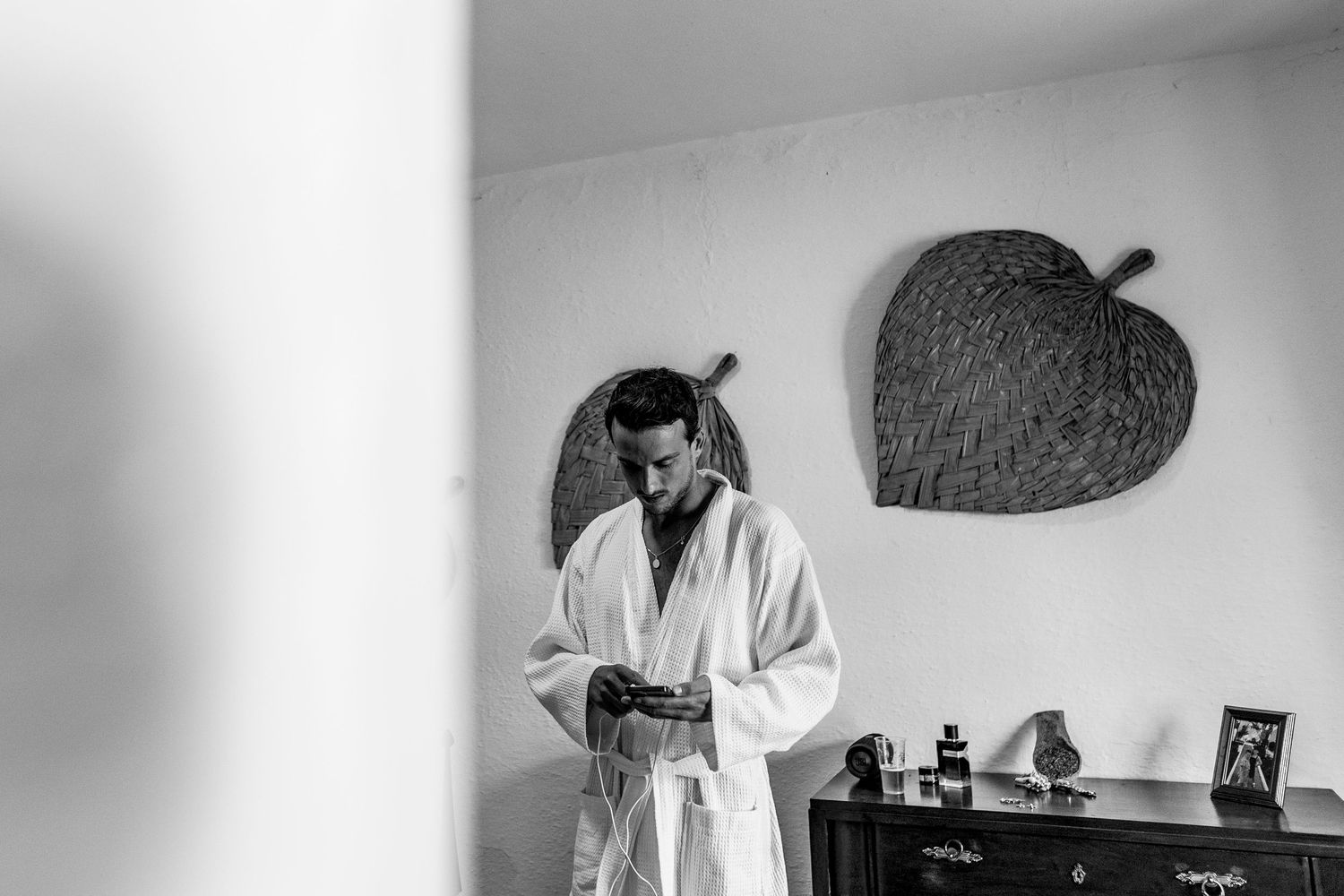 Black and white photos showing someone arranging flowers and decor in an interior space.