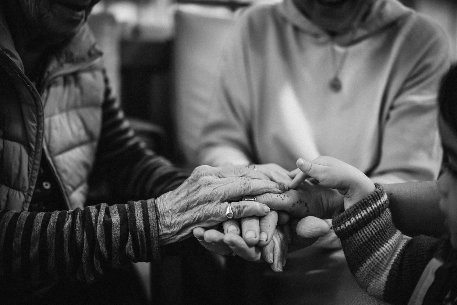 Hands holding and passing various smartphones in a black and white collage of connected images.