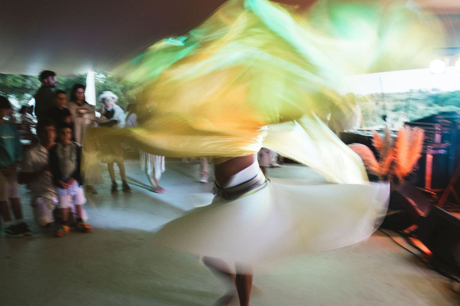 Colorful silk fabric flows through the air creating ethereal light trails and patterns during a performance.