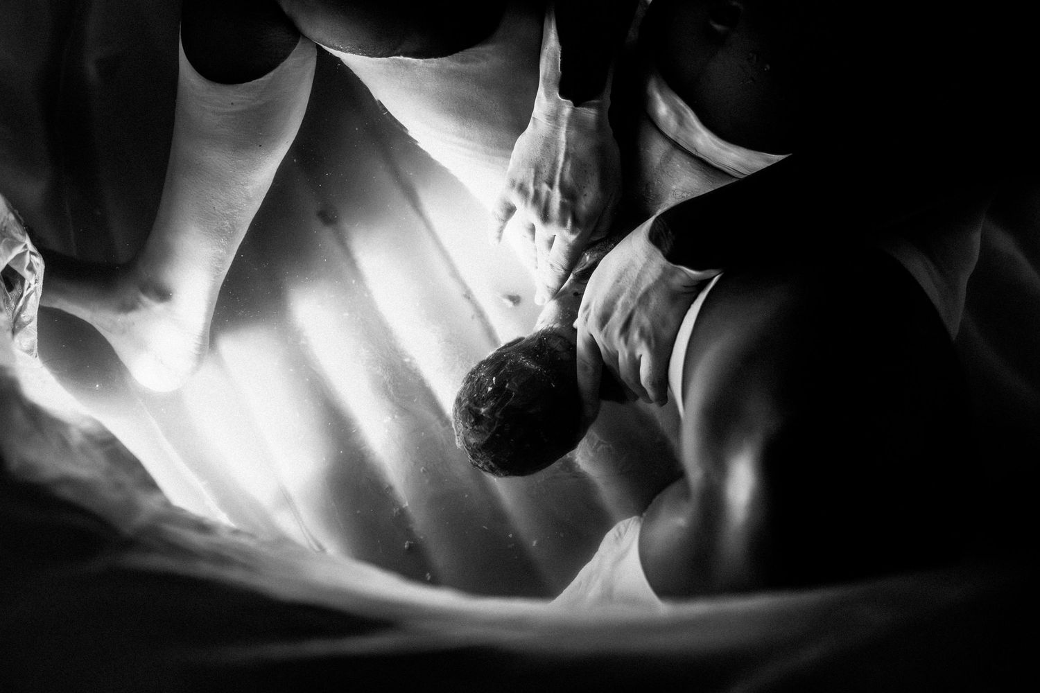 Dramatic black and white capture of a birth moment.