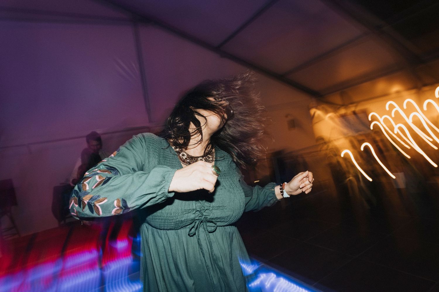 Dynamic dance moves captured in a dark venue with dramatic lighting effects.