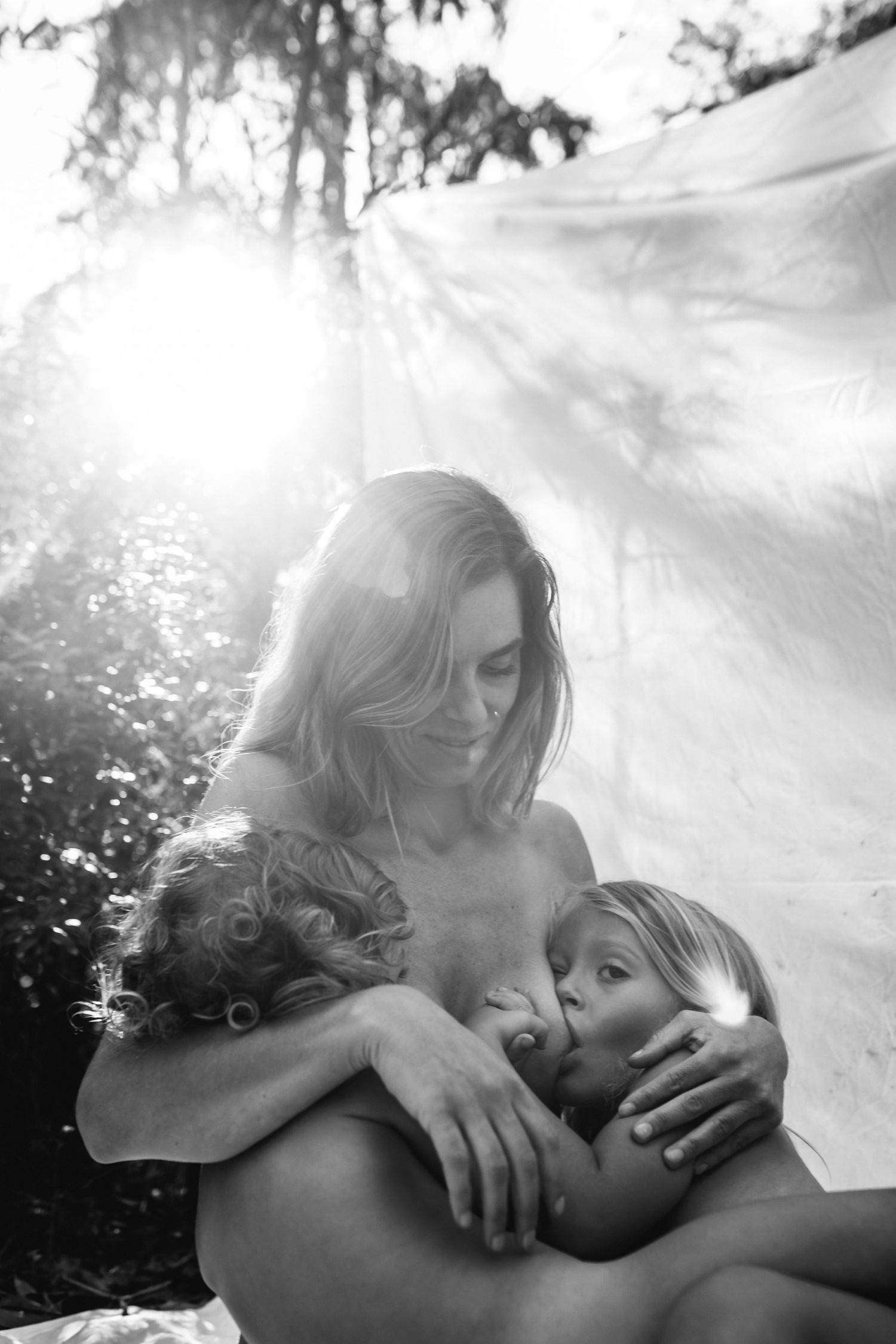 A romantic black and white photo sequence showing an intimate embrace between two people in soft lighting.