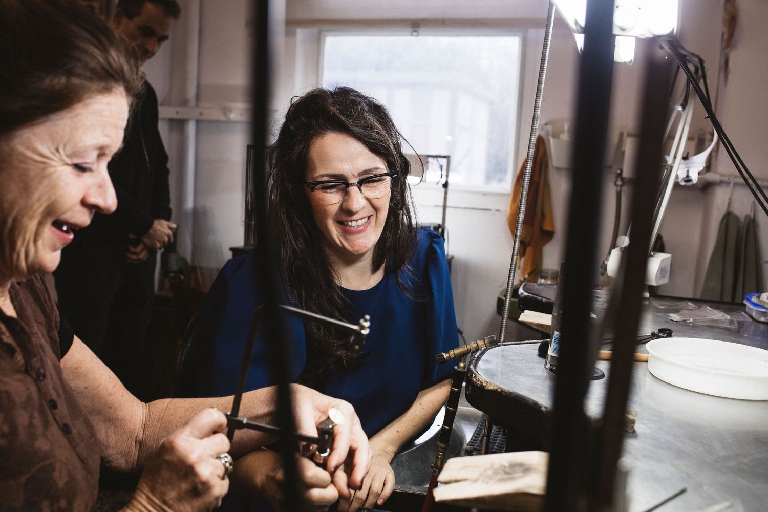 People working together and smiling in a bright office space while collaborating on a project.