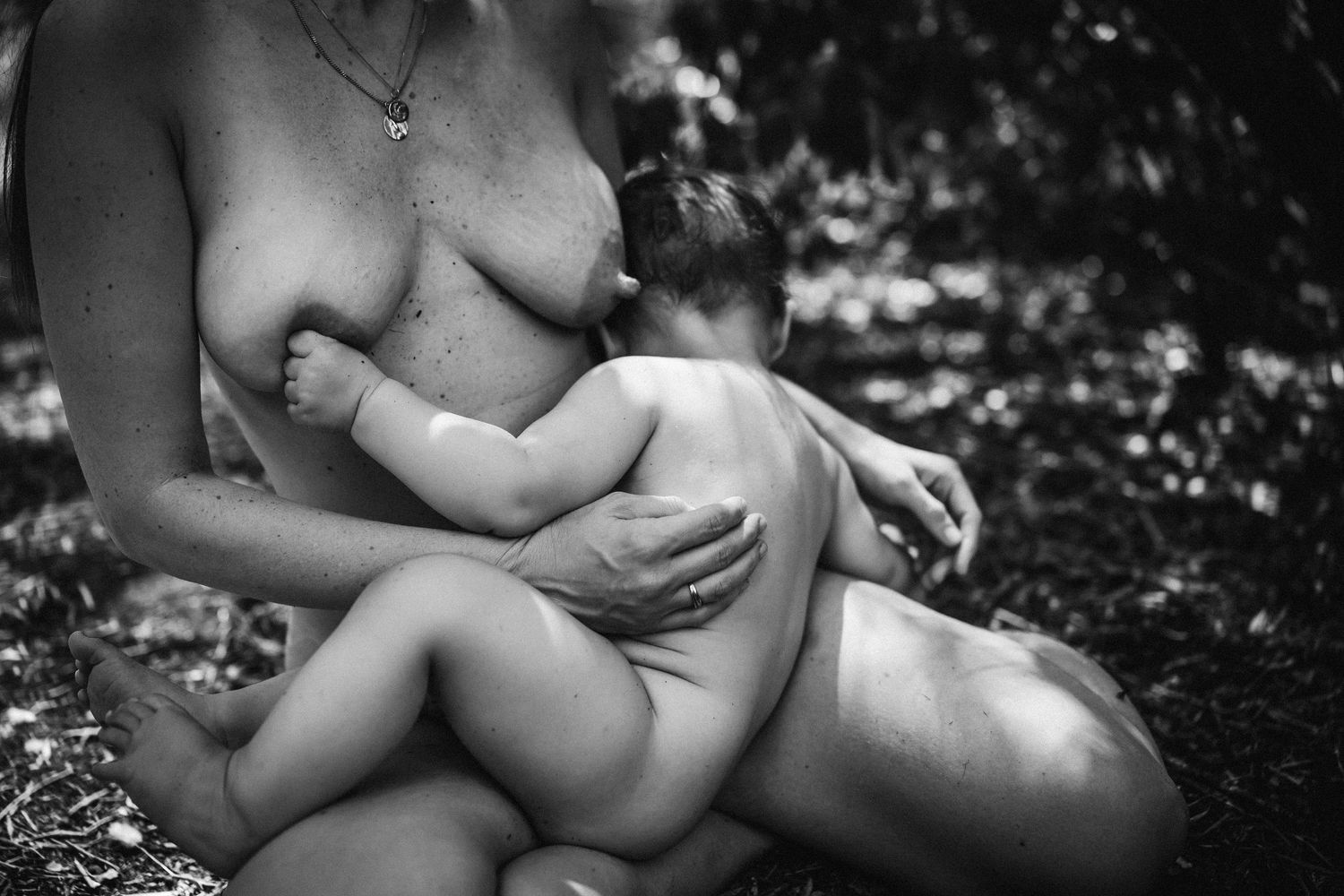 A tender black and white photograph of nurturing and intimate maternal bonding in nature.