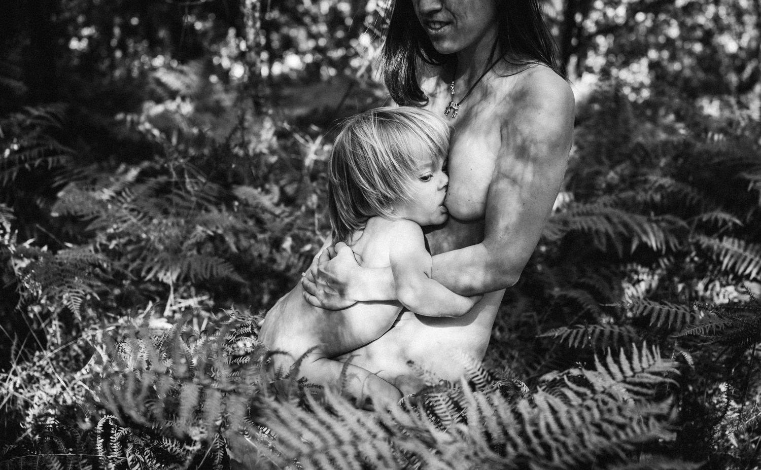 Artistic portrait among ferns and forest foliage in natural lighting.