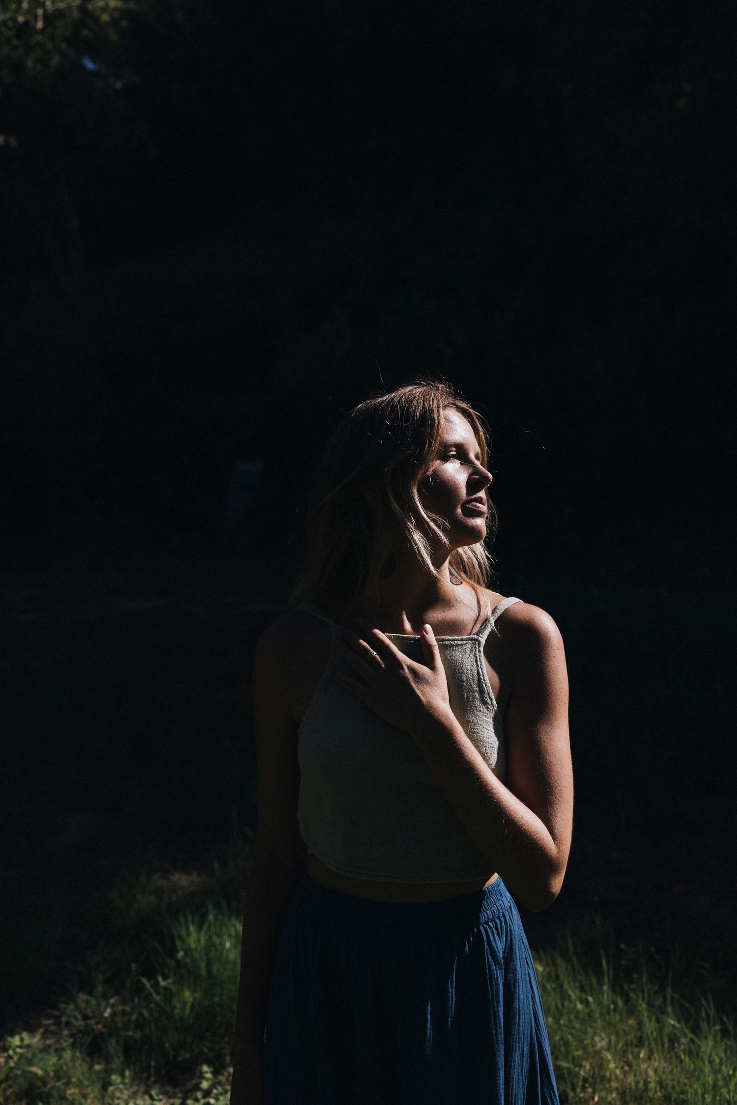 Moody portrait series in dark setting with dramatic side lighting.
