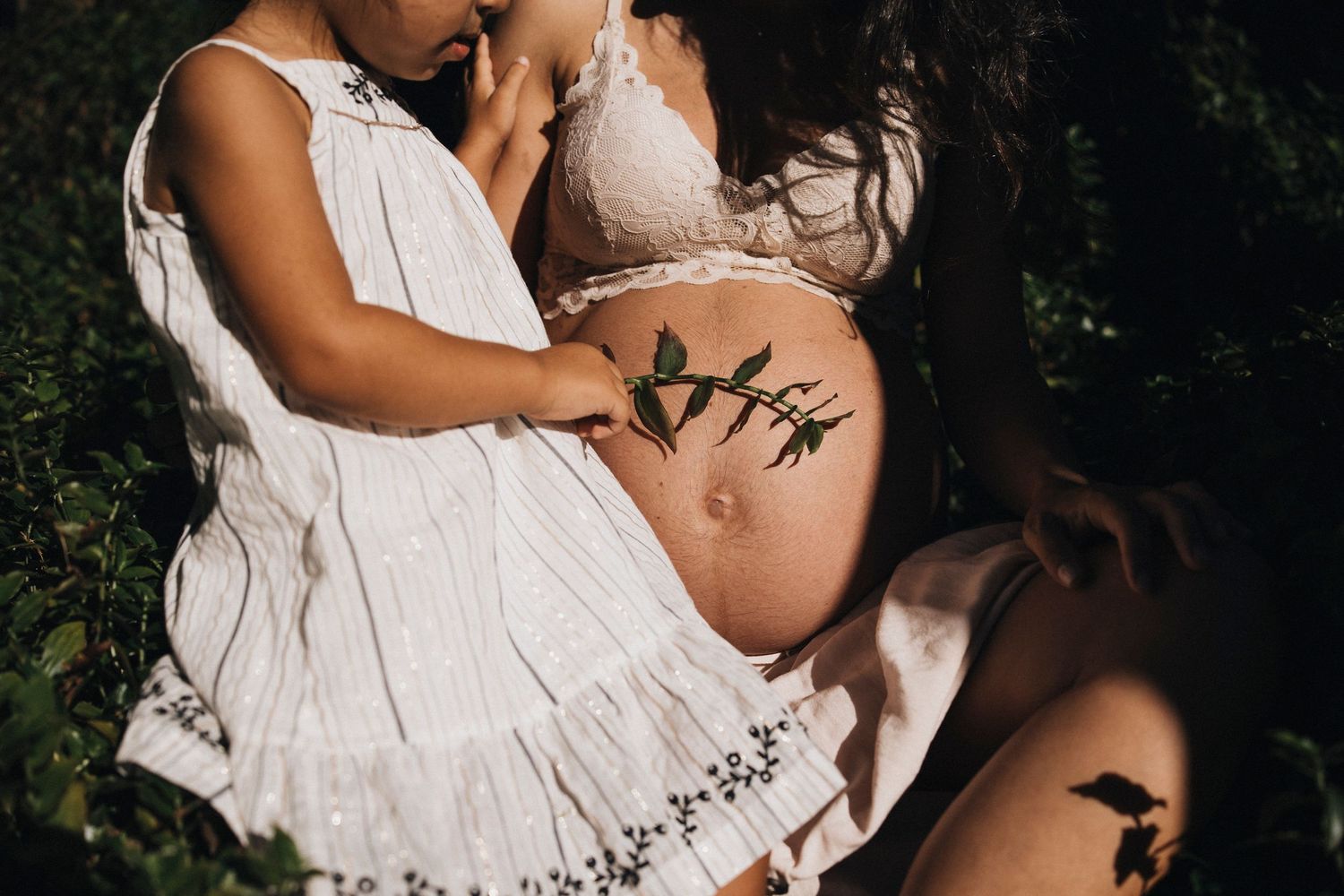 Outdoor maternity session featuring a white dress against natural scenery.