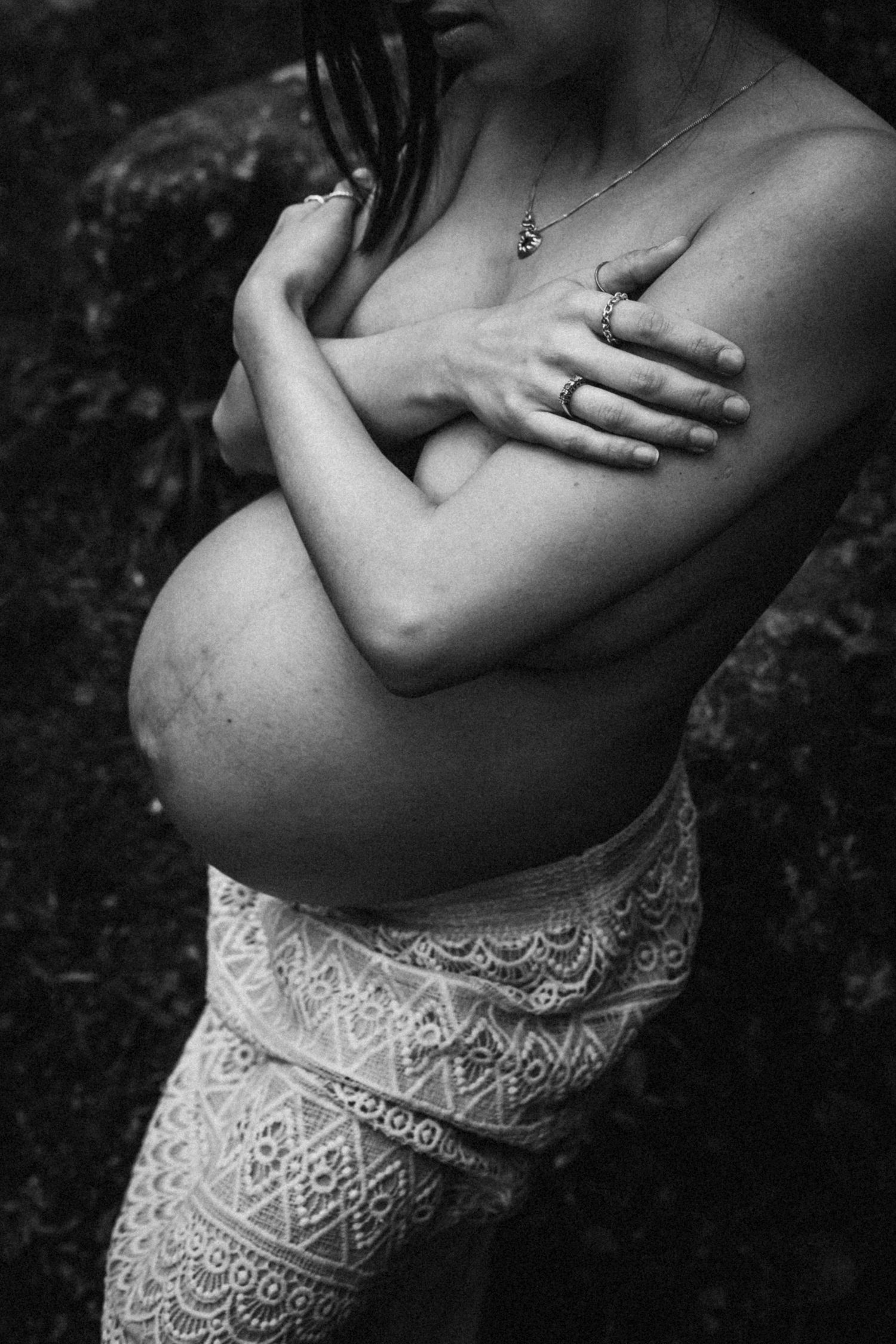 Black and white maternity photos focusing on the belly with lace details.