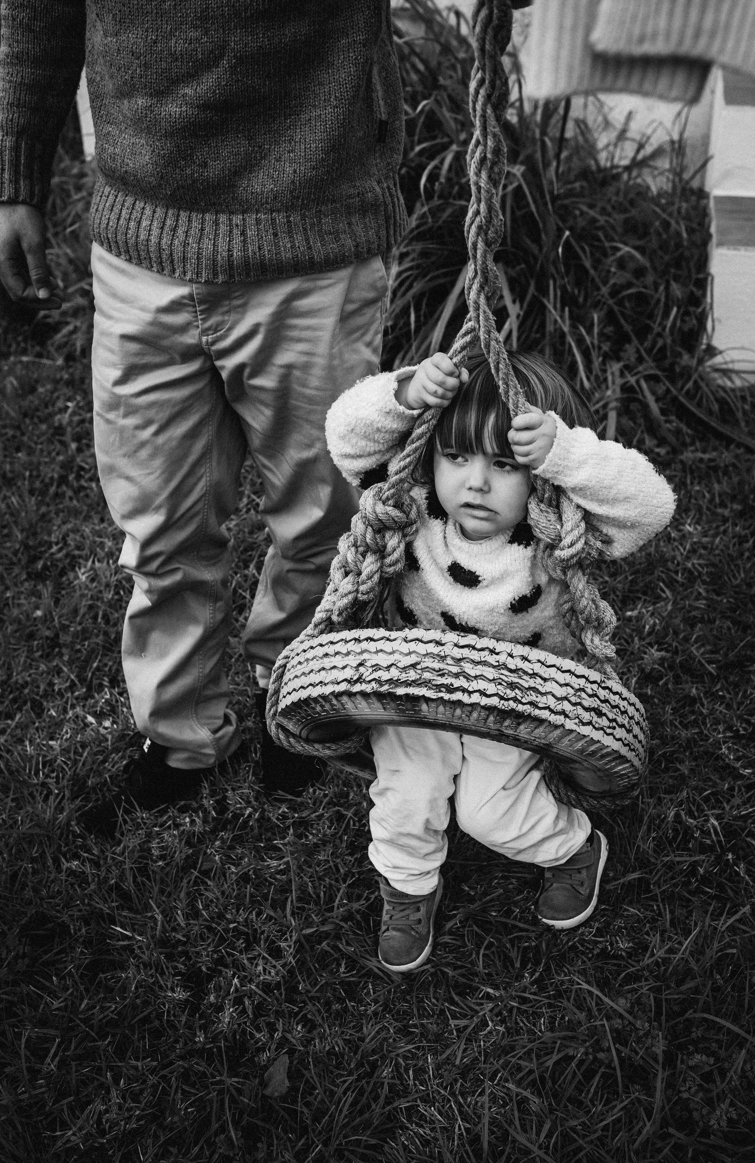 Black and white series of children playing with a basket in tall grass.