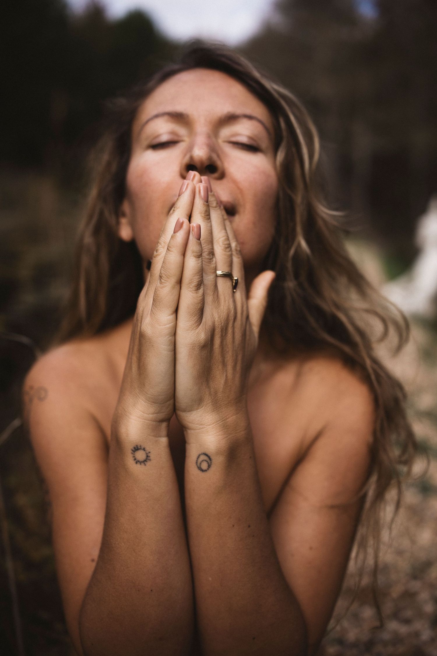 A sequence of photos showing someone covering their face with their hands while wearing rings and a sun tattoo.