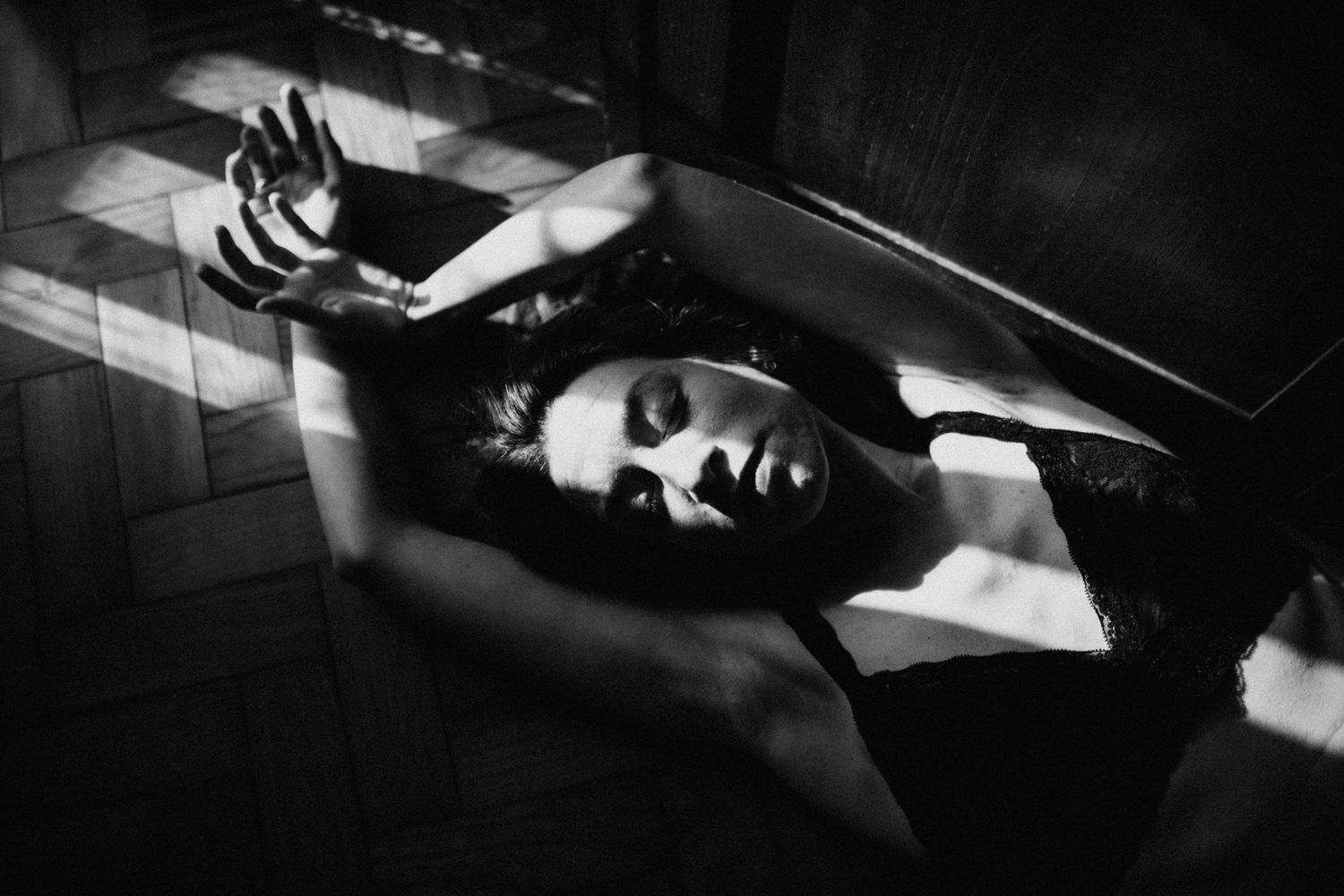 Dramatic black and white portrait in film noir style with strong shadows.