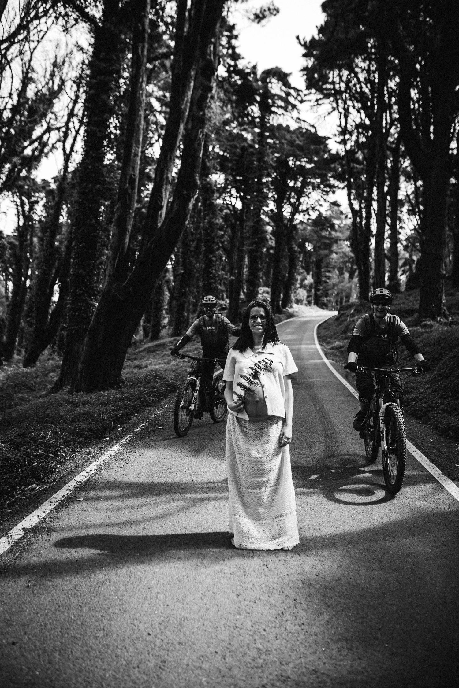 Artistic black and white sequence showing figures walking along a curved forest road.