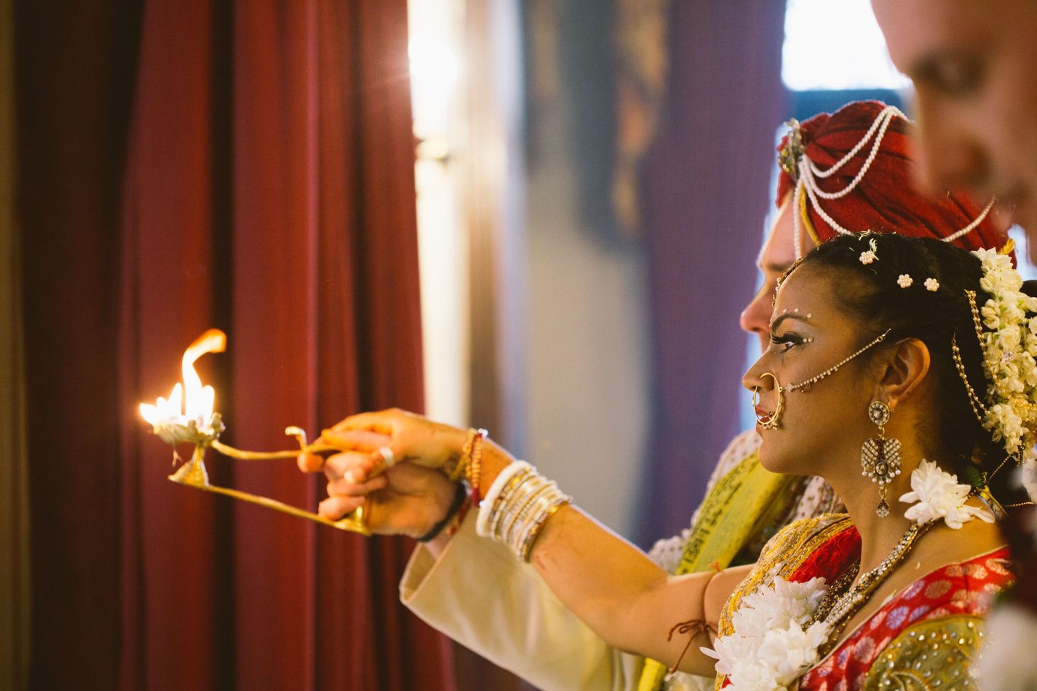 Traditional Indian wedding ceremony with ceremonial fire and ritual offerings being performed.