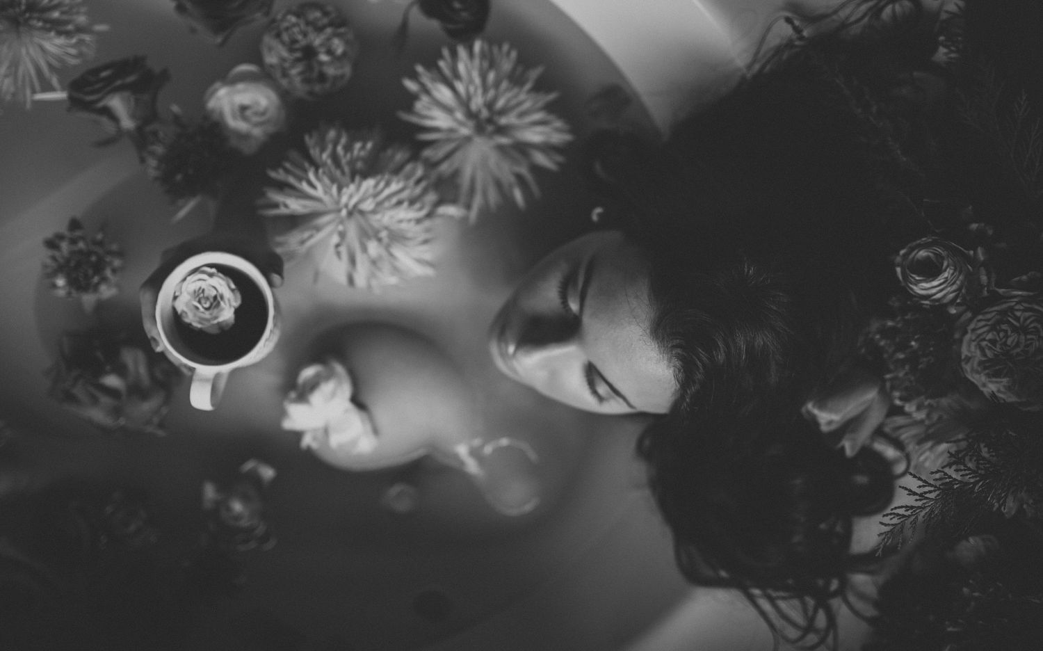 Black and white floral artwork with ethereal petals and abstract shapes creates a dreamy, atmospheric composition.