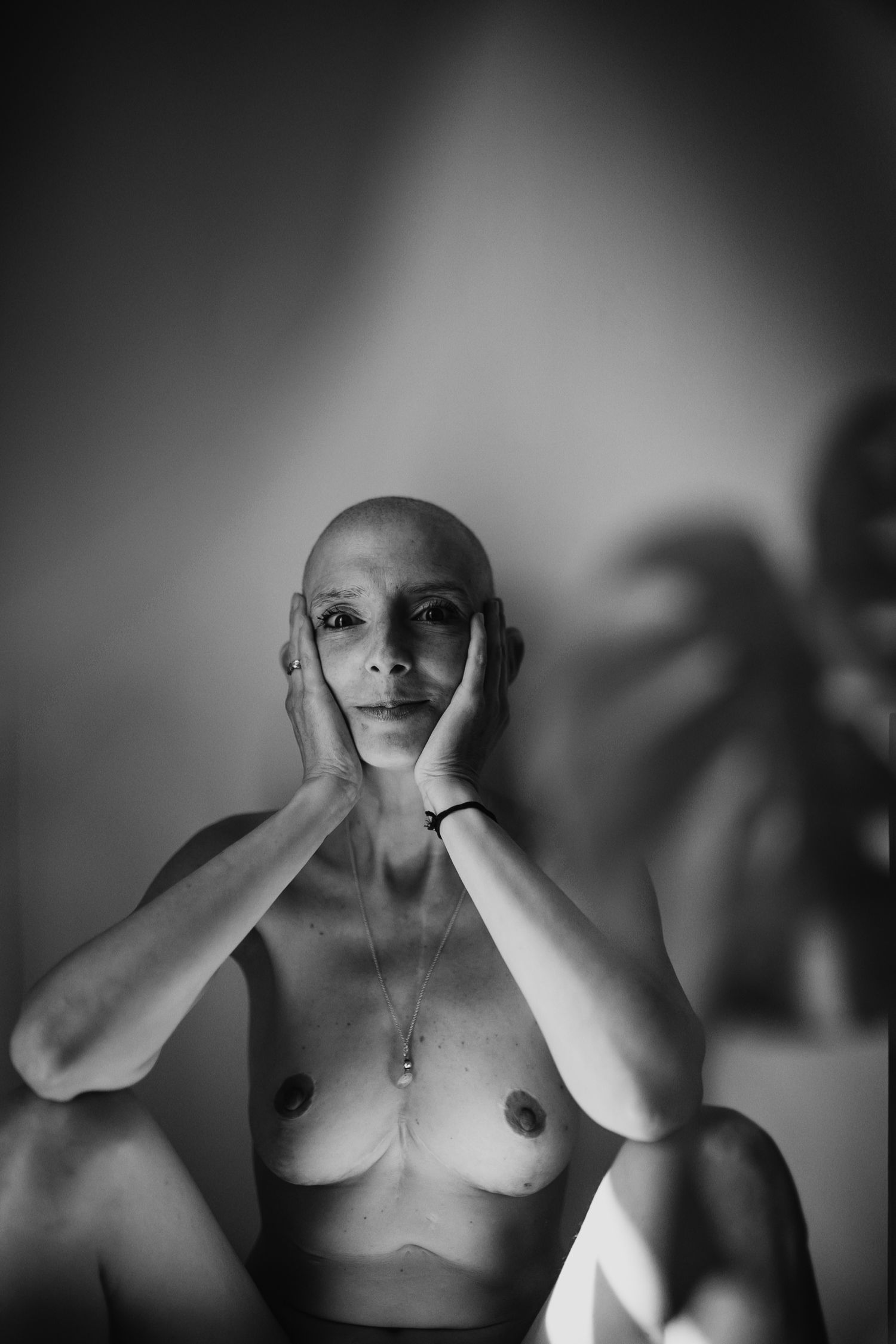 Artistic black and white photo series showing a figure covering their face with hands in different poses.