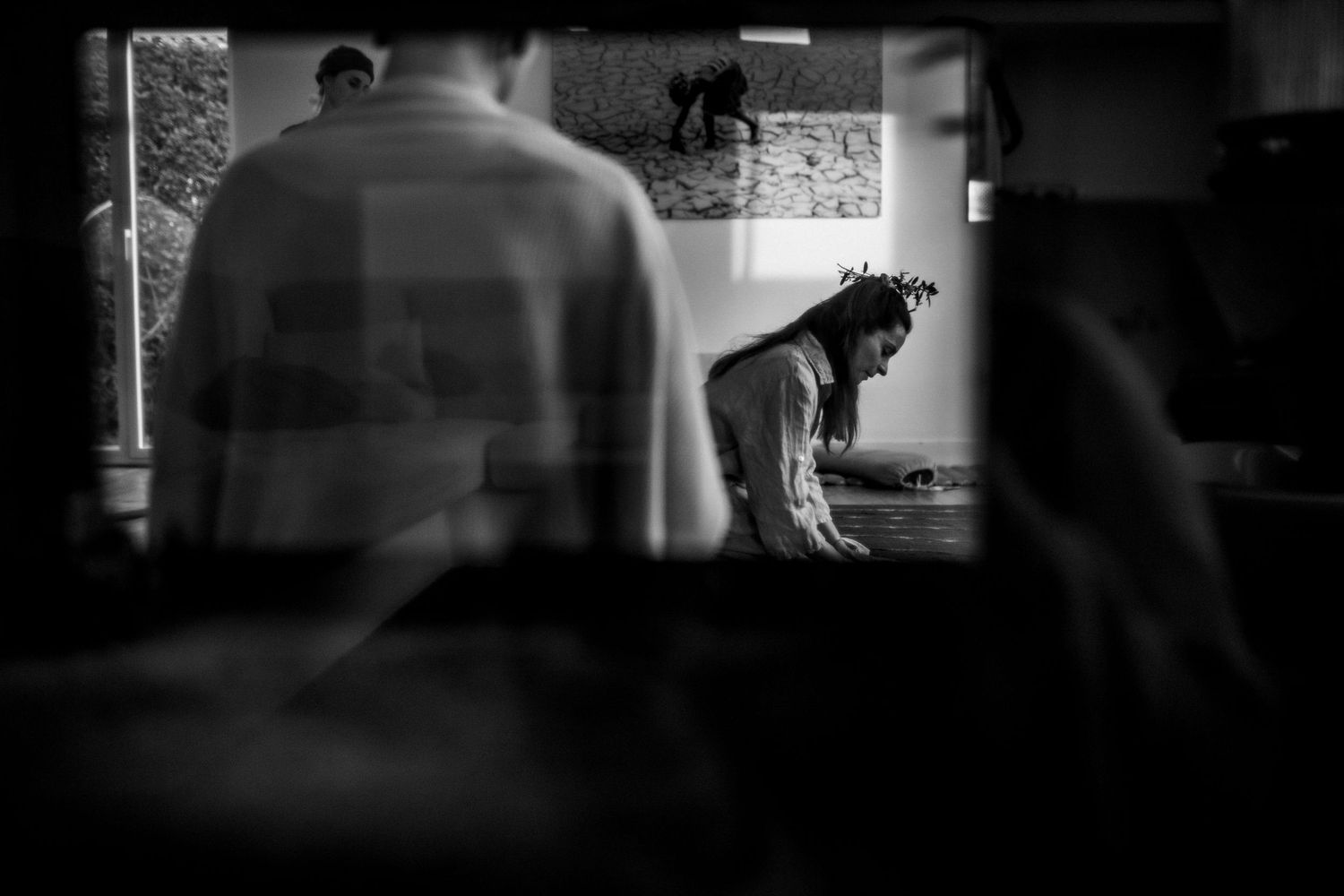 Moody silhouettes against windows create a cinematic panoramic composition in low light.