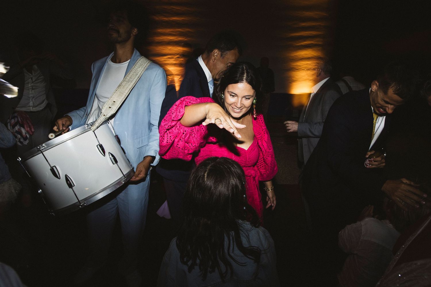 Dark and moody reception photos showing guests dancing in dramatic lighting.