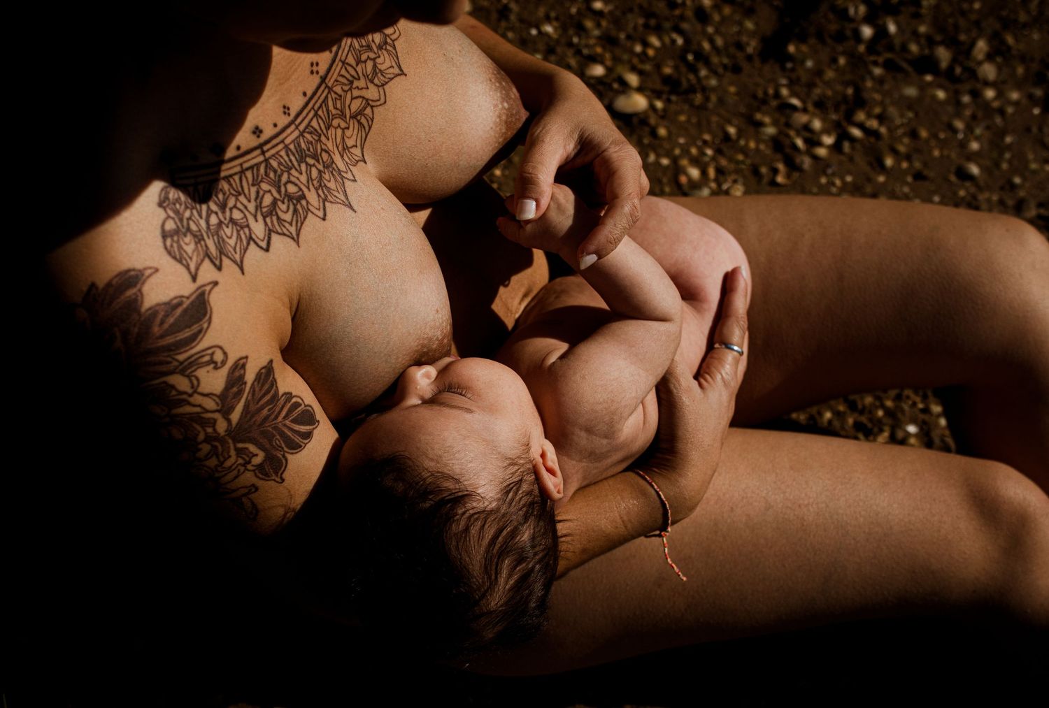 Decorative henna tattoo design featuring intricate floral and mandala patterns adorns bare skin in warm lighting.