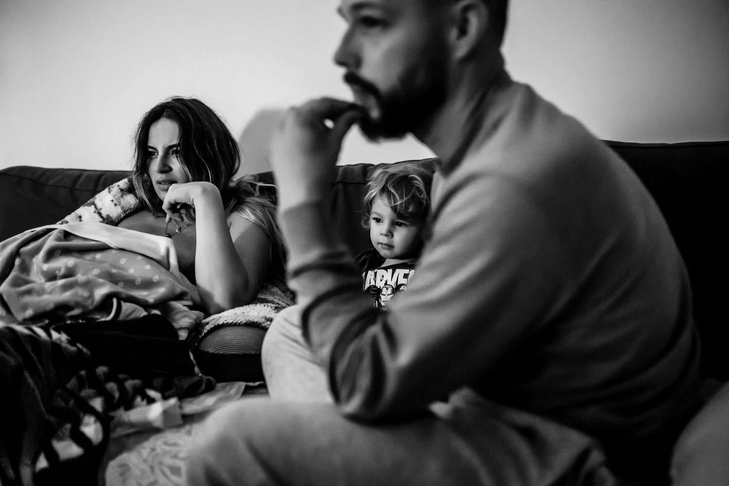 Black and white portrait series capturing candid moments in moody lighting.