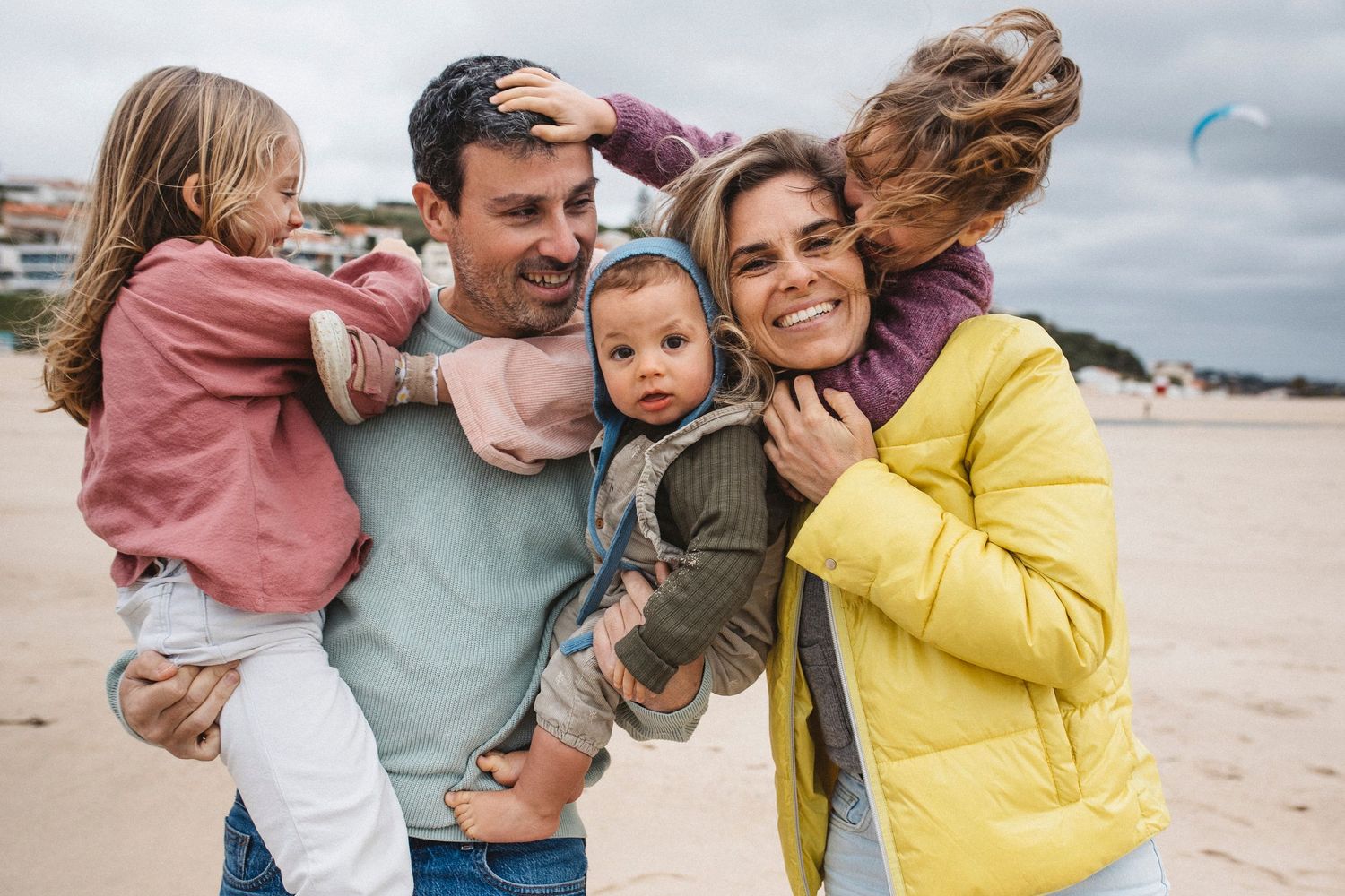 A collection of candid beach photos showing a family enjoying time together near the ocean.