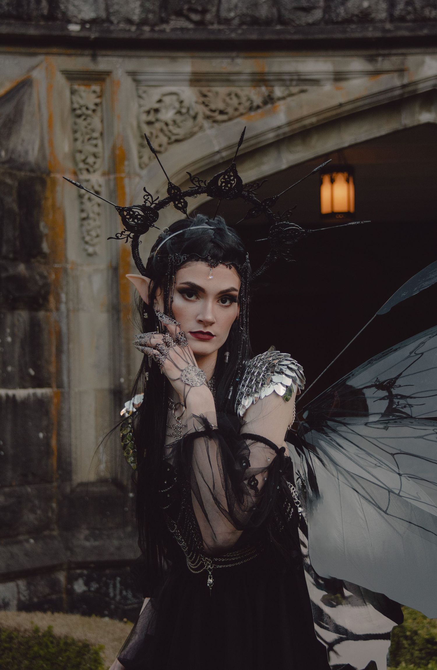 Portrait of a dark fairy queen outside her castle during blue hour
