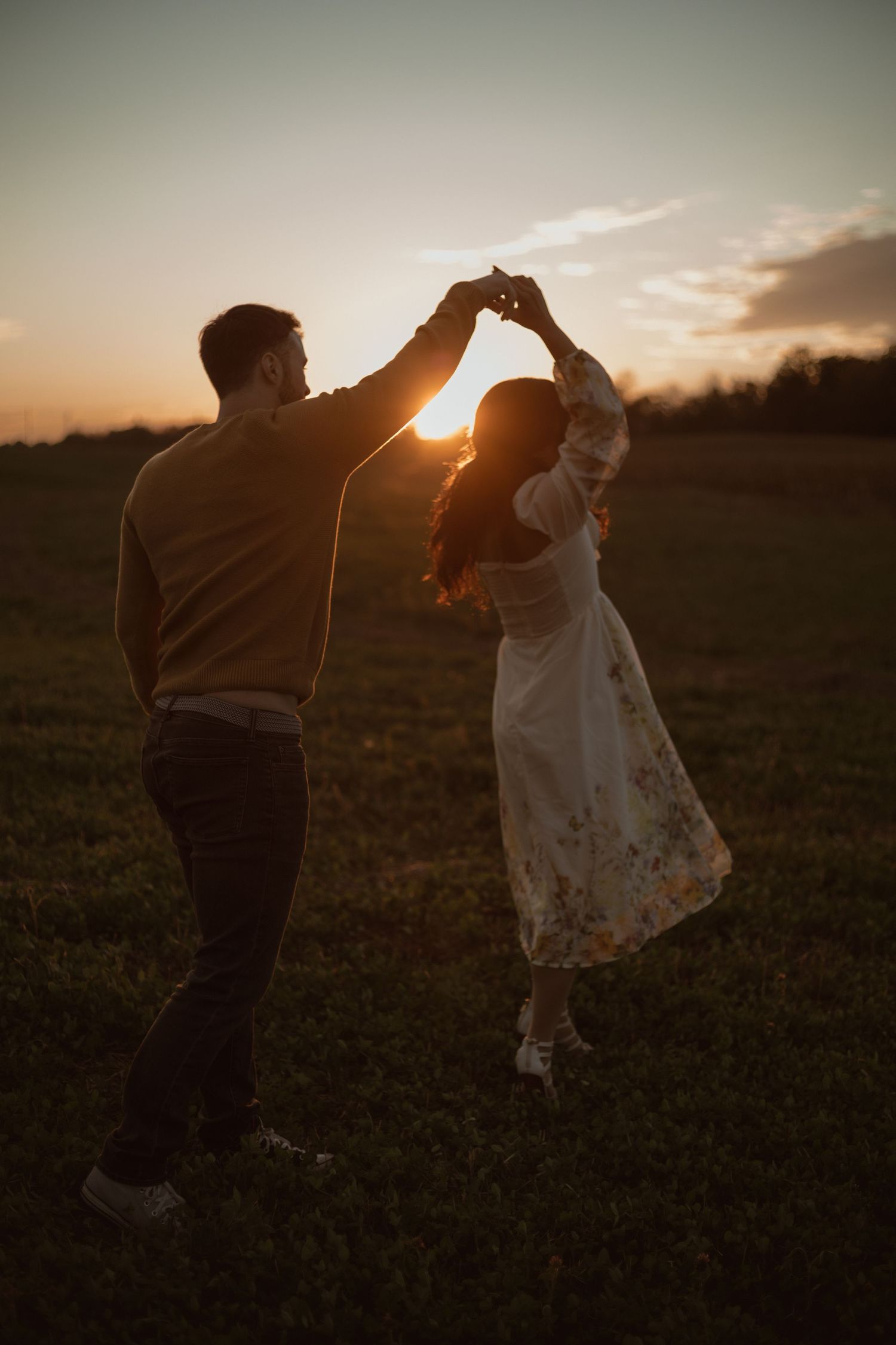 Husband swirls wife around during golden hour in Caledonia for a sun set session.