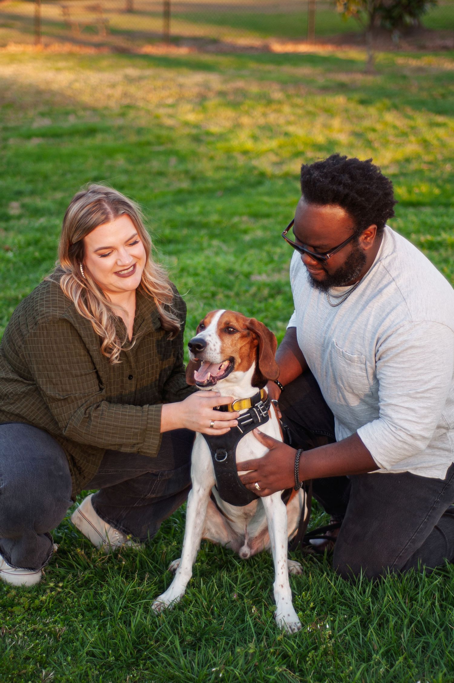 Couple interacting with their dog during a relaxed outdoor portrait session.