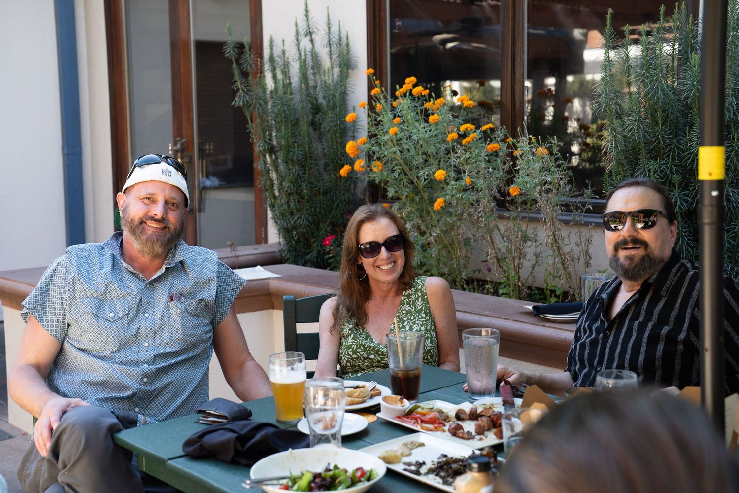Family sharing a meal together at an outdoor restaurant gathering.