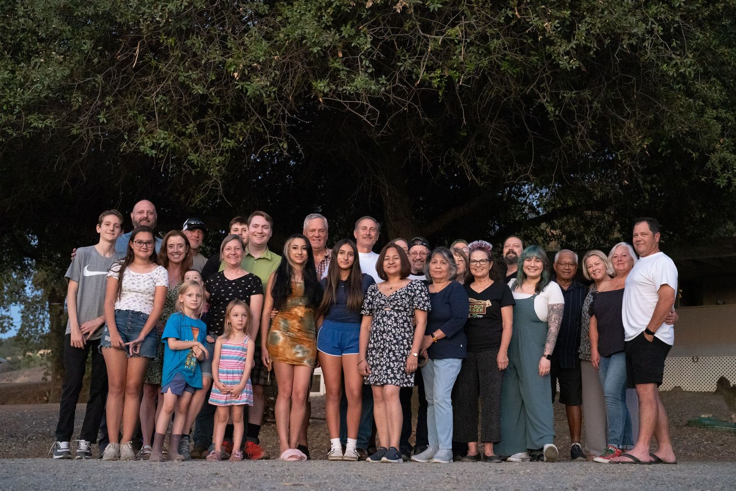 Large group of family and friends gathered together for an outdoor group portrait.