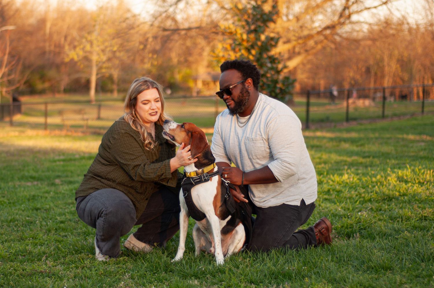 Couple posing with their dog during a golden-hour outdoor portrait session.