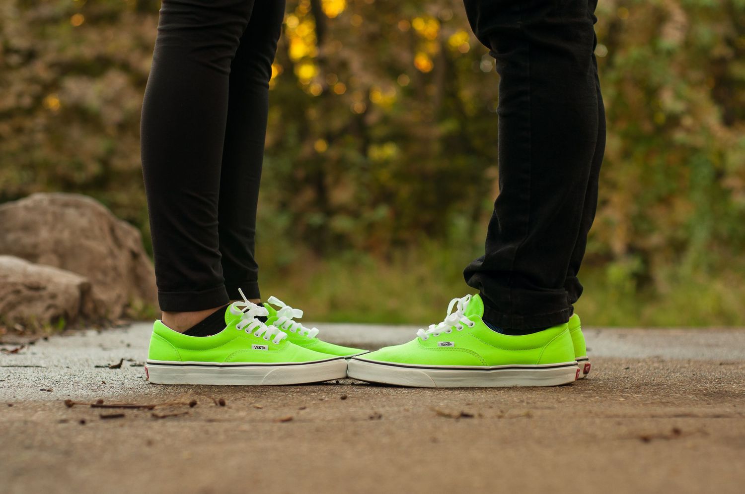 Close-up of a couple's matching bright neon green shoes during an outdoor portrait session.