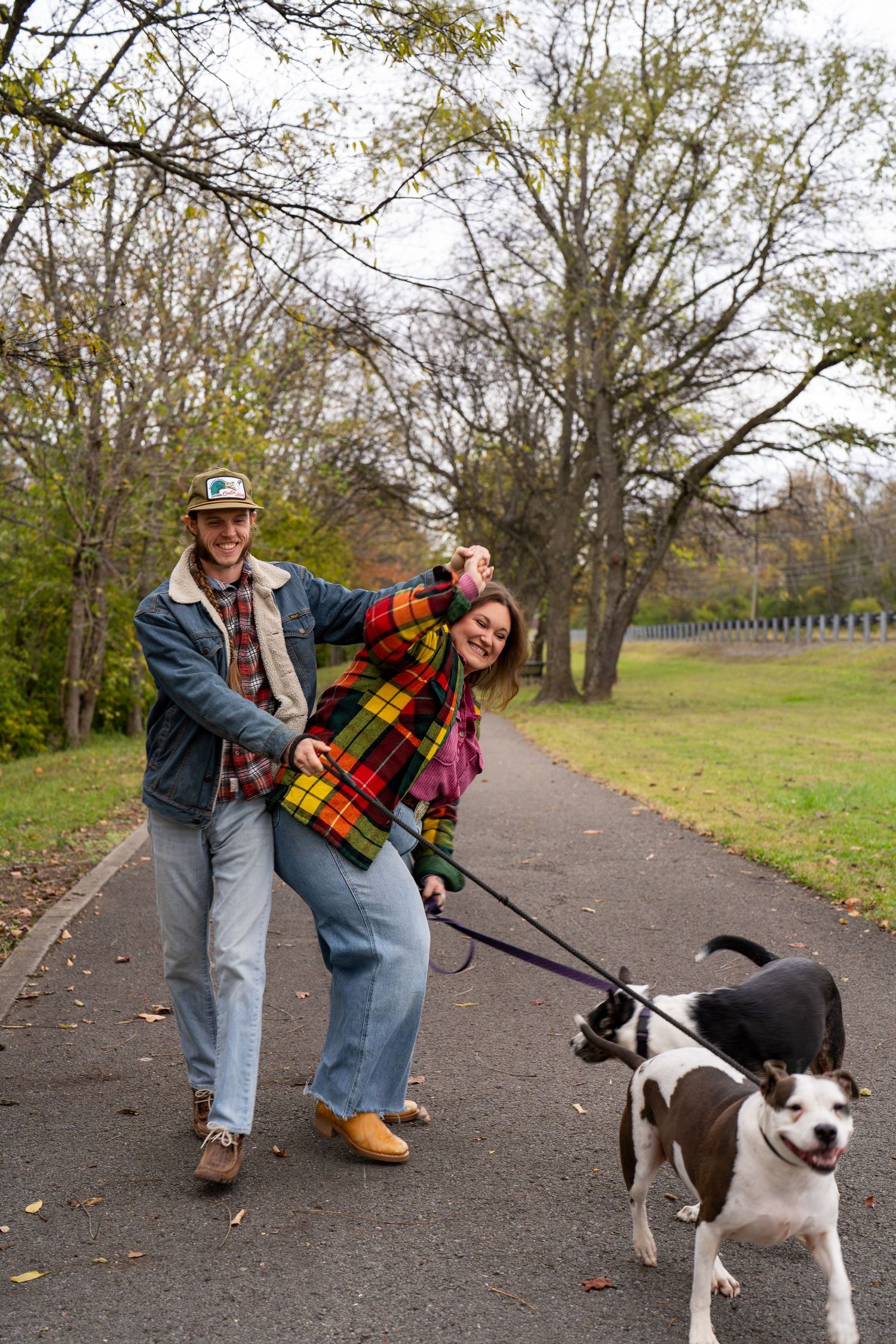 Couple walking their dog together during a casual outdoor portrait session.