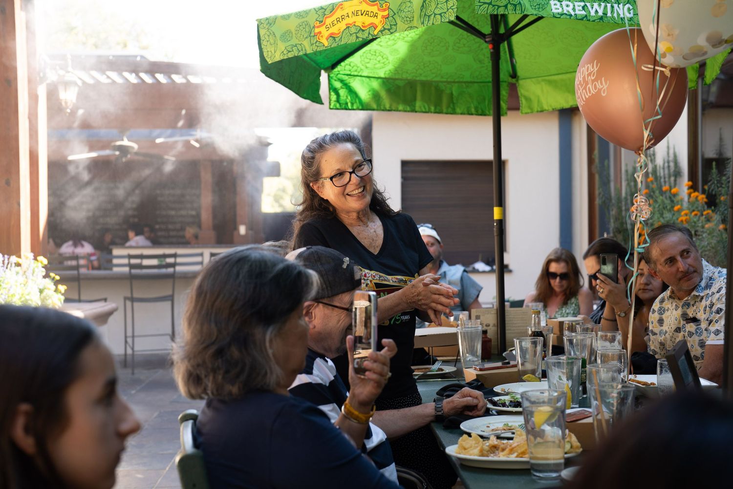 Group of family members sharing a meal together at an outdoor restaurant.