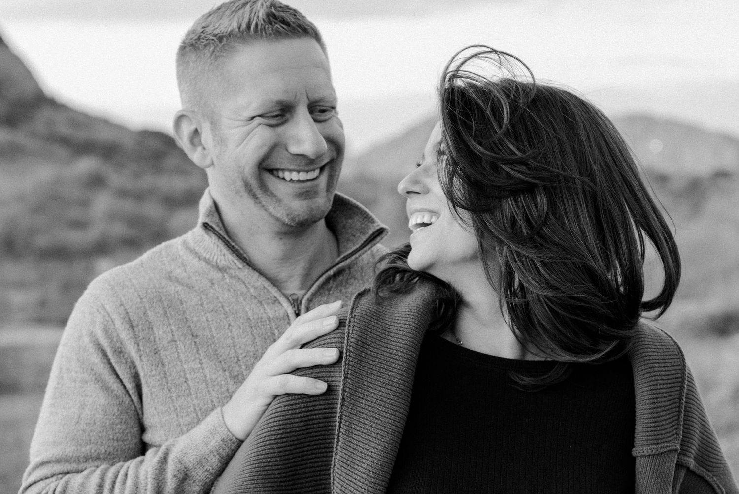 Candid black and white image of a couple laughing with each other in the desert at Papago Park in Tempe, Arizona.