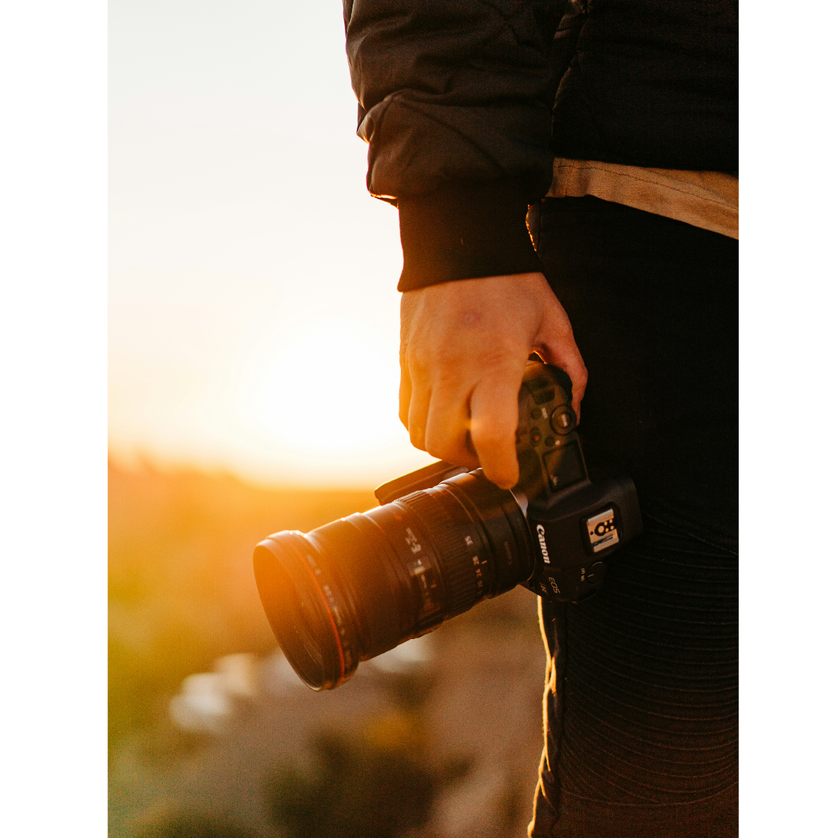 Student with a camera in their hand during golden hour.