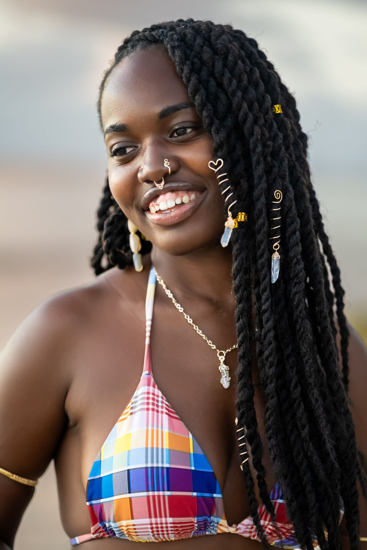 Portrait series showing colorful swimwear and braided hairstyle with decorative accessories against blurred background.
