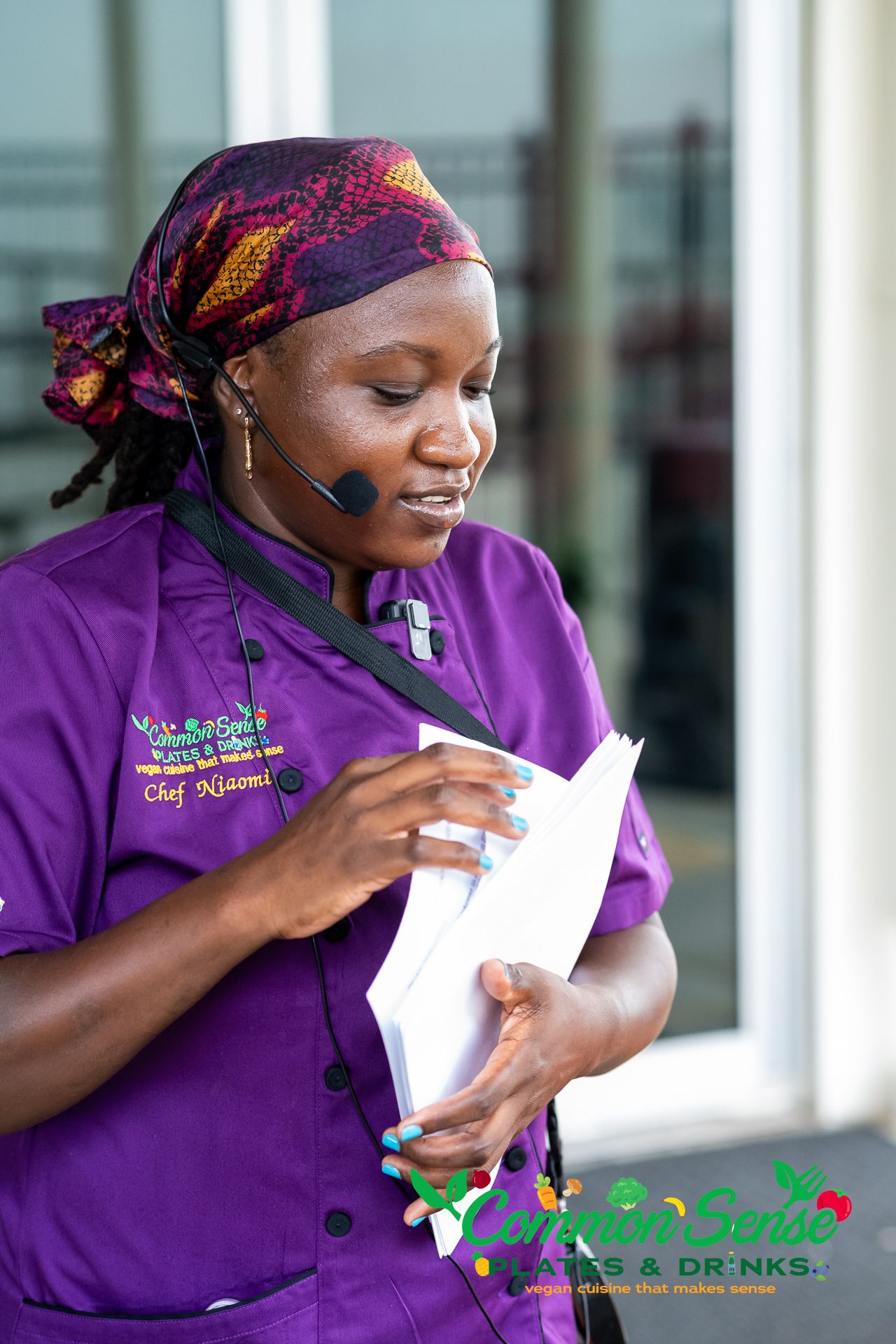 Healthcare worker in purple uniform writing notes in a professional setting.