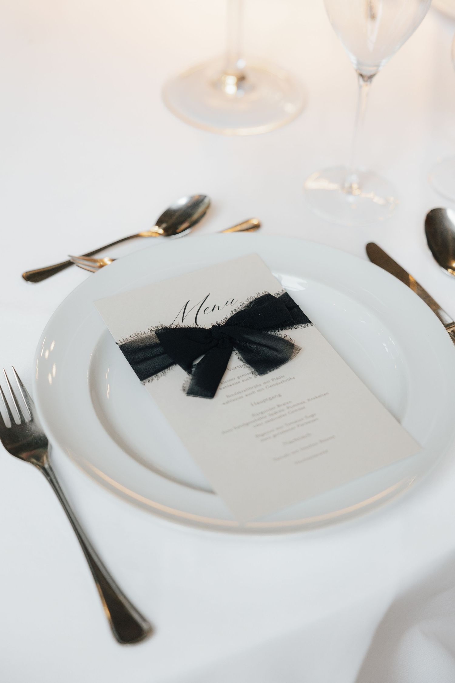 Detailaufnahme eines stilvoll gedeckten Hochzeitstisches mit Menükarte und Schleife – Fine-Art-Hochzeitsdeko in Beckum, Münsterland