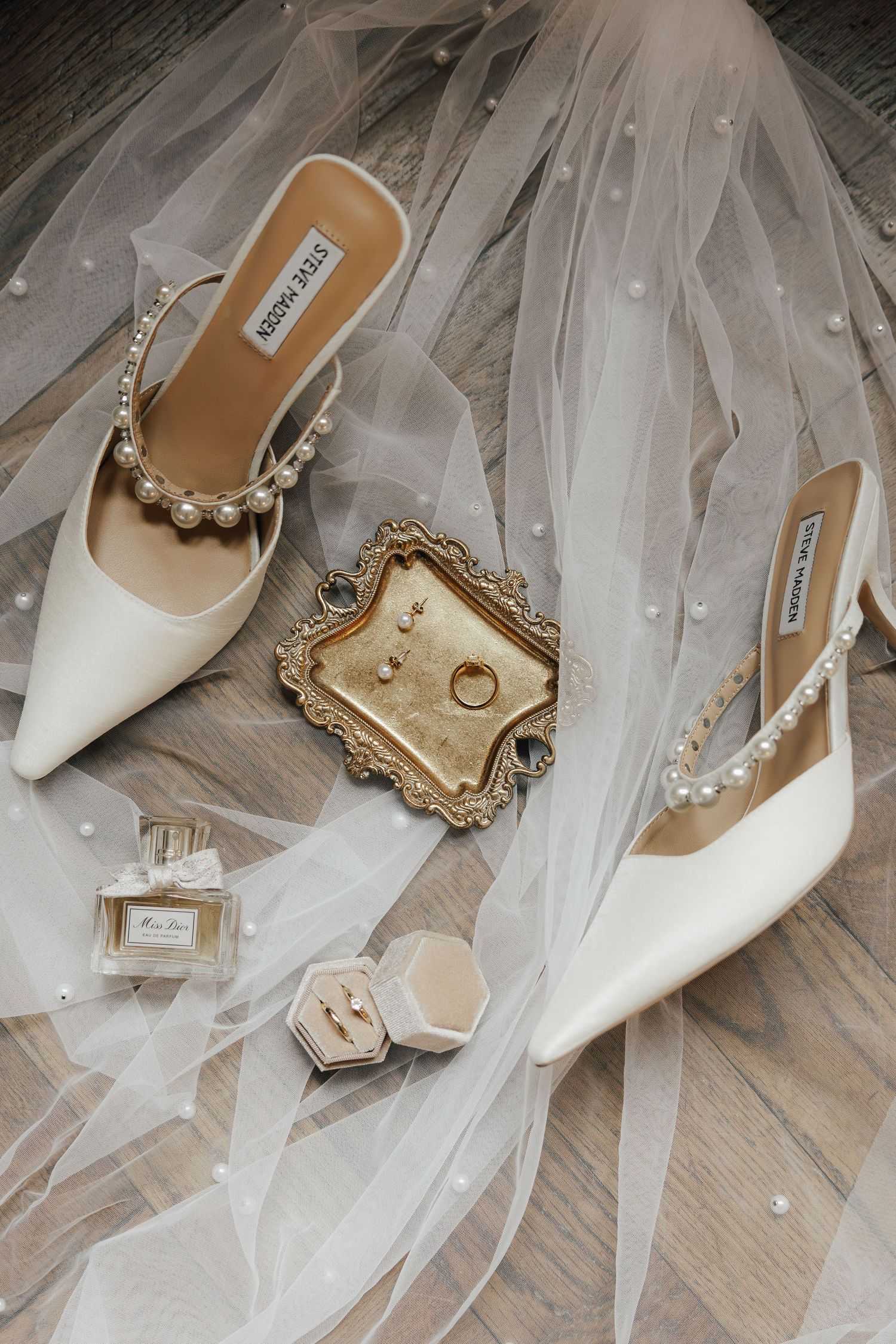 Brautschuhe und Accessoires auf hellem Stoff – ästhetische Hochzeitsdetails mit feinen Goldtönen, aufgenommen im modernen Fine-Art-Look