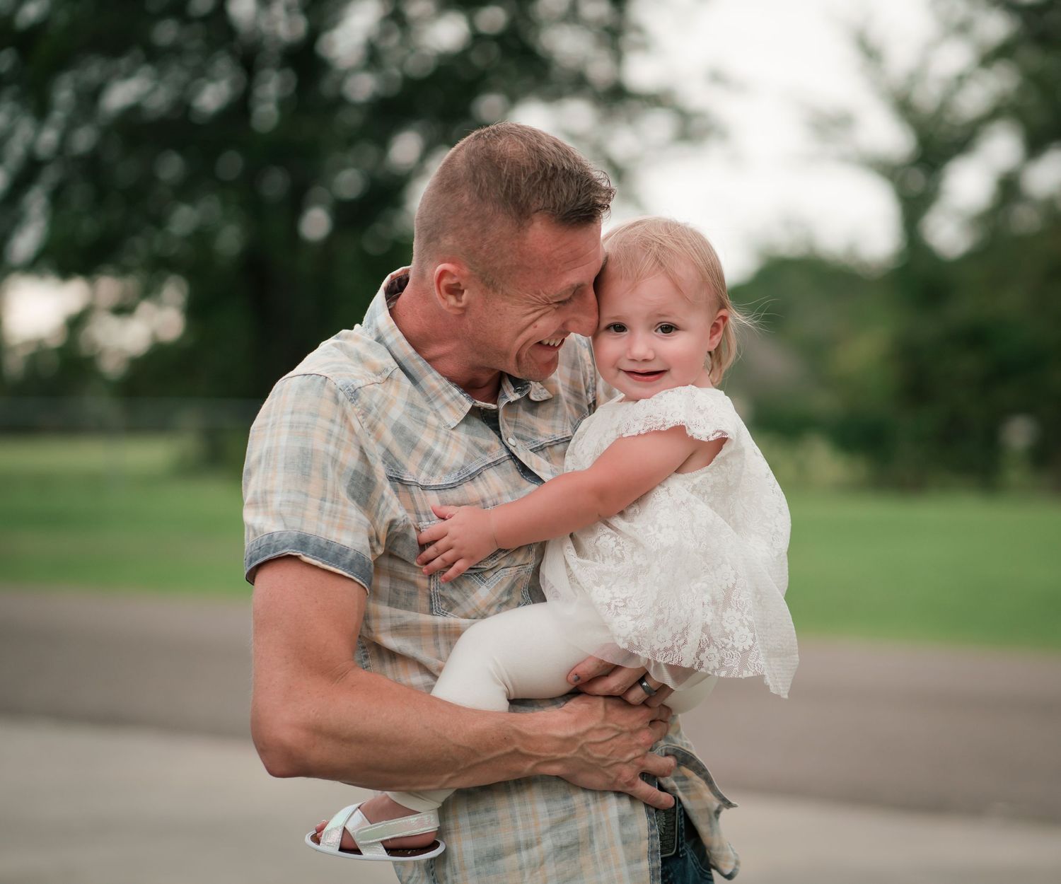 A sweet outdoor moment captured between parent and child on a summer day.