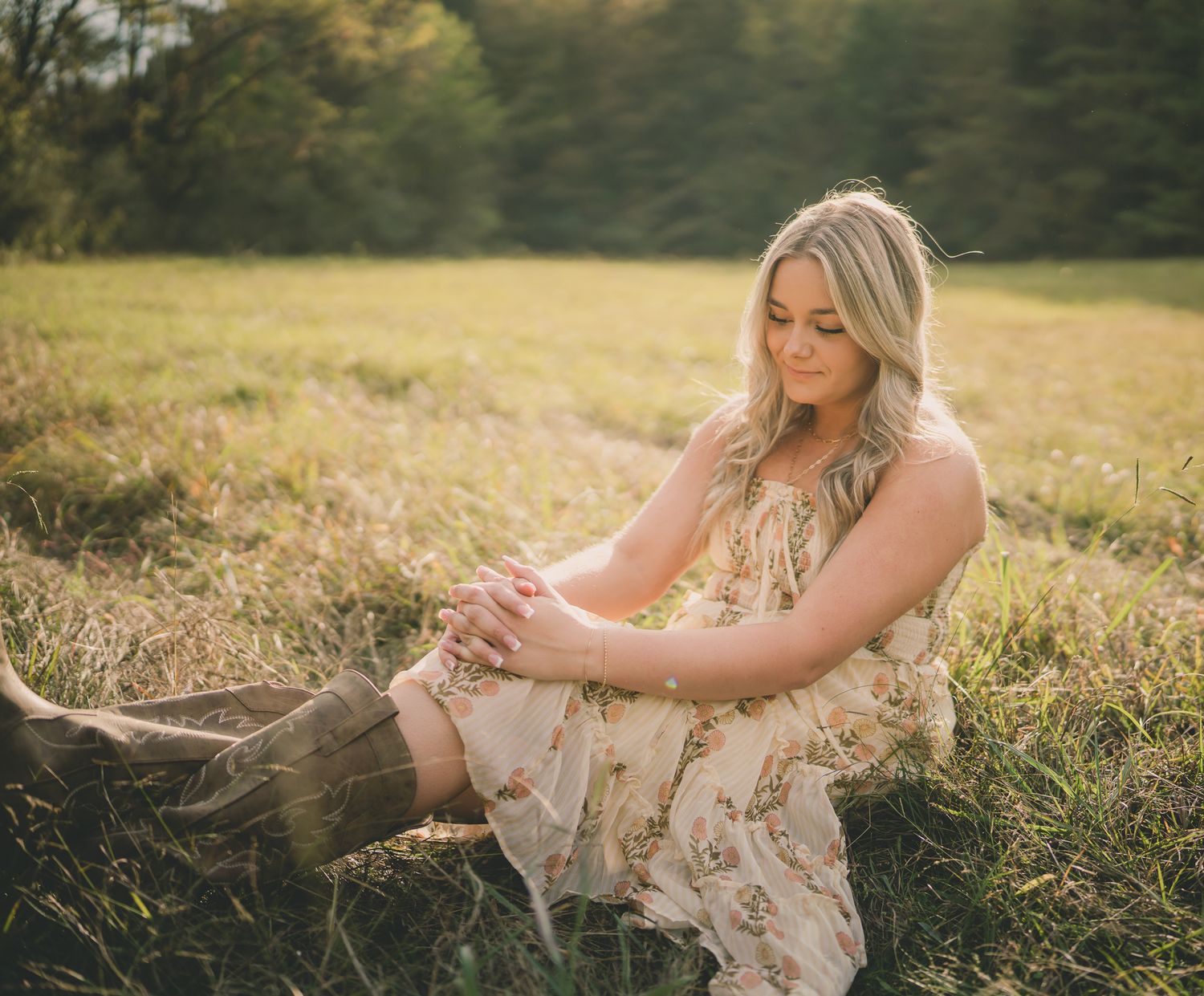 A dreamy outdoor portrait session in a golden field with tall grass and warm sunset lighting.